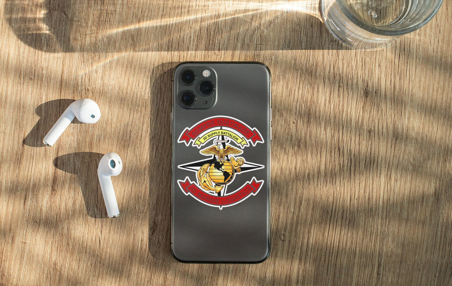 a phone with a sticker on it next to ear buds