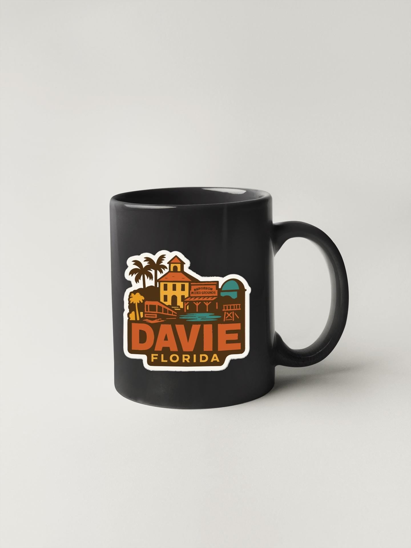 A black coffee mug with a colorful graphic depicting a tropical scene and the text "DAVIDE FLORIDA" printed on it.