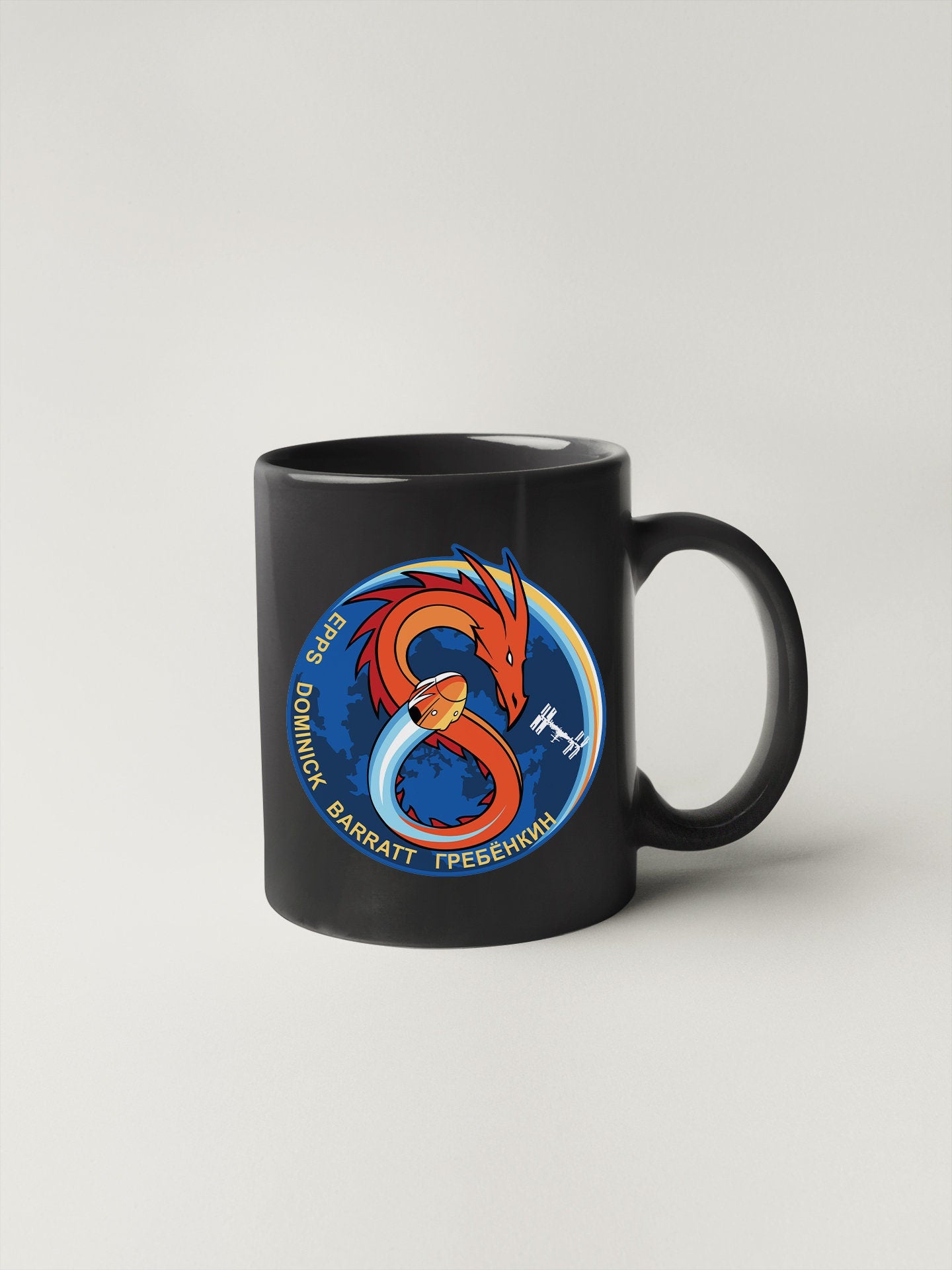 a black coffee mug with a dragon on it