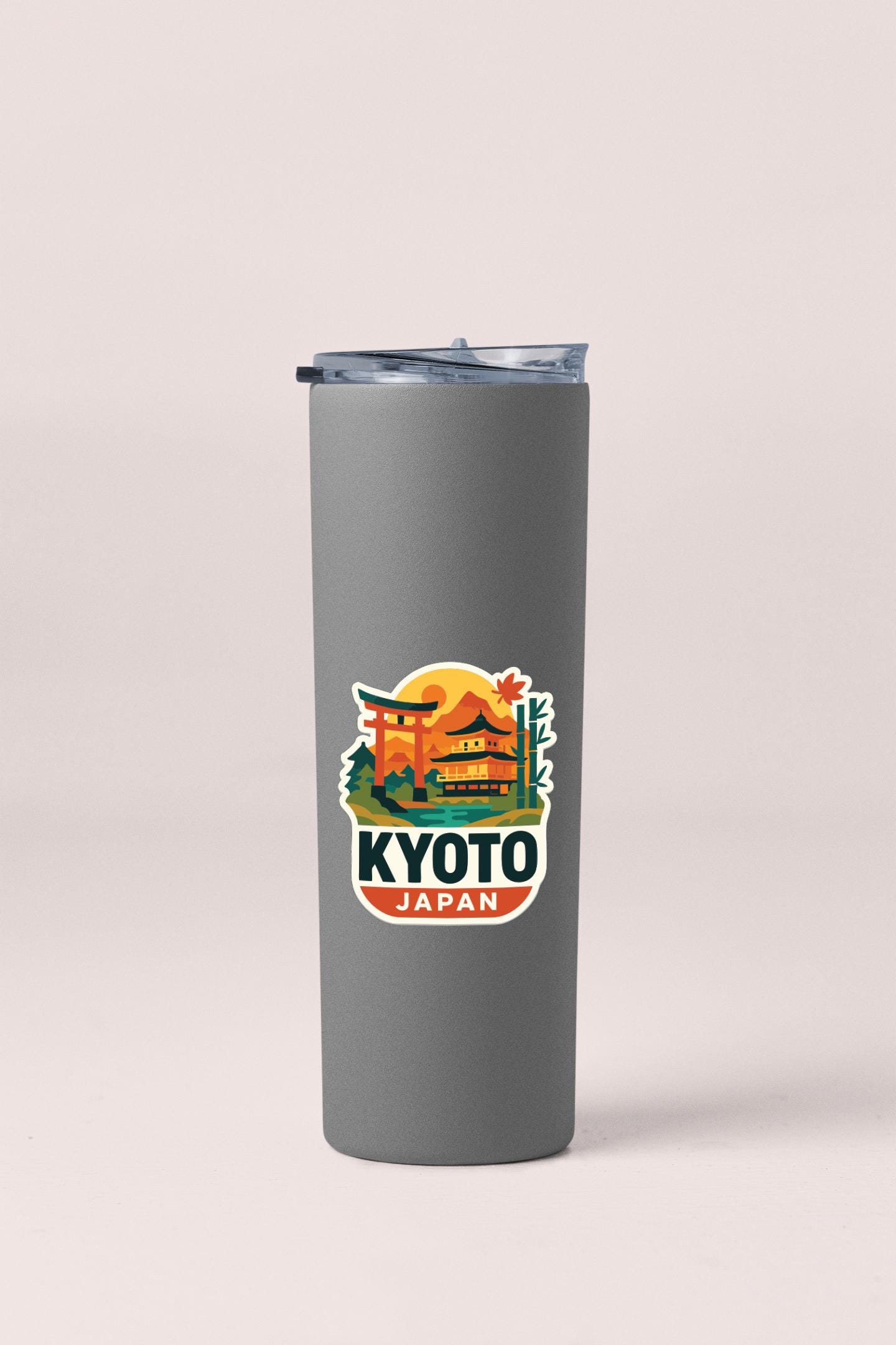 A gray insulated tumbler with a sticker depicting a Japanese temple and the text "KYOTO JAPAN" printed on it.