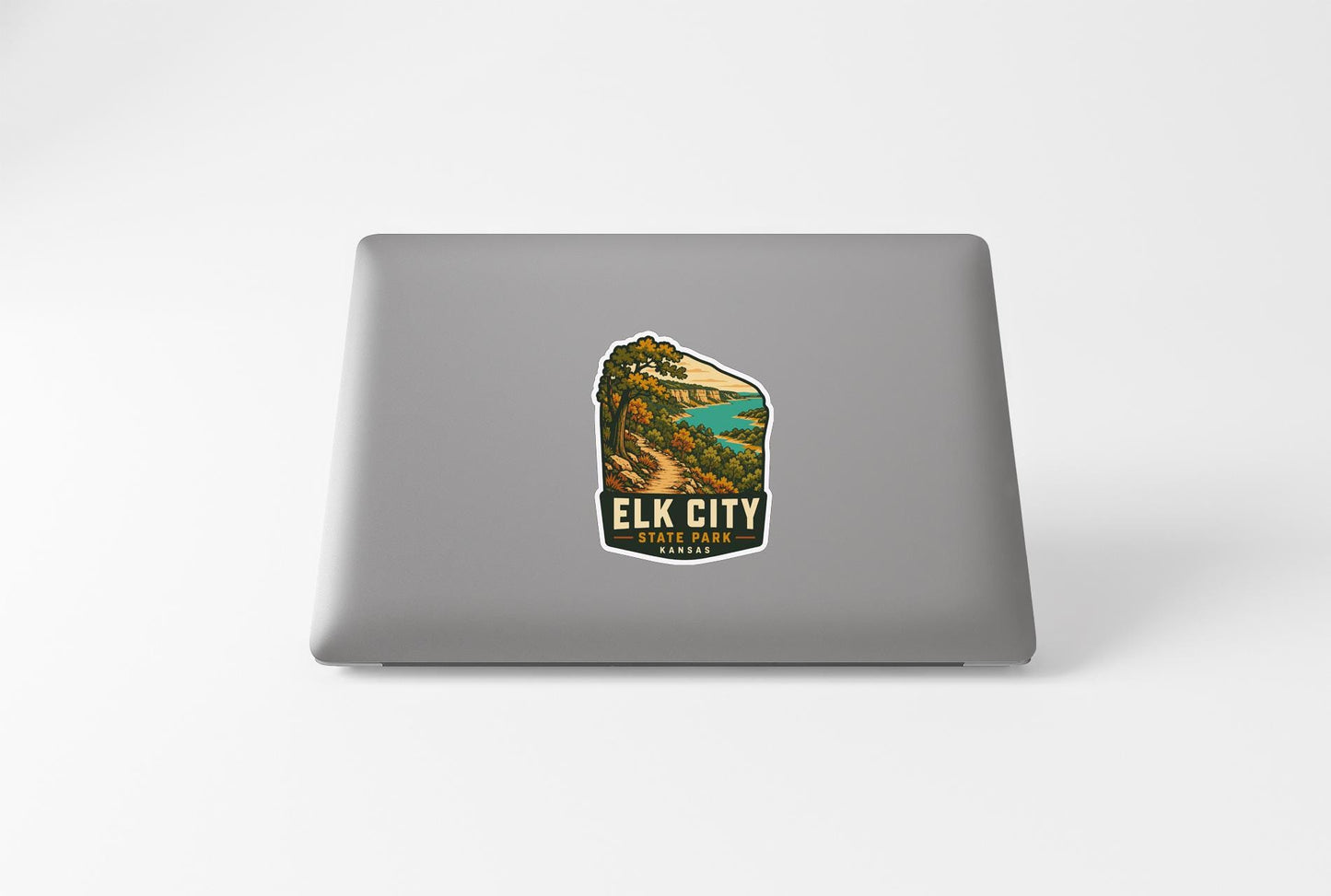 A sticker on the back of a laptop, depicting a scenic landscape with a mountain and a lake.