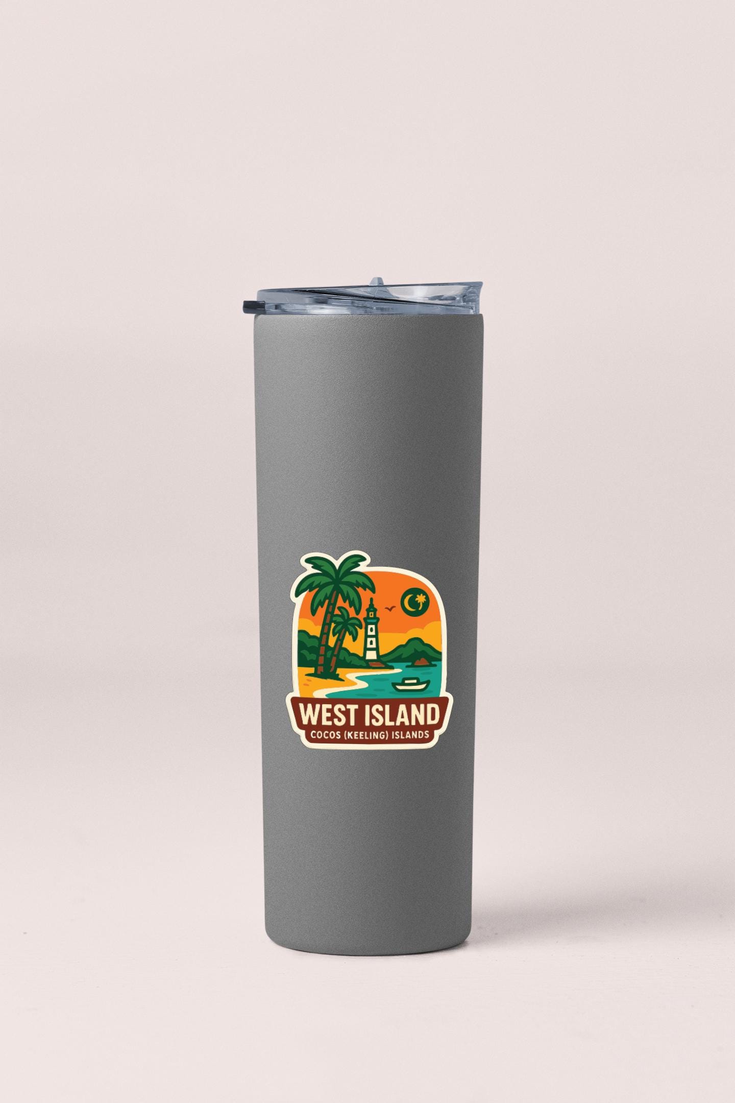 A gray insulated tumbler with a label that says "WEST ISLAND" and "Cousin Kiteboarding Islands".