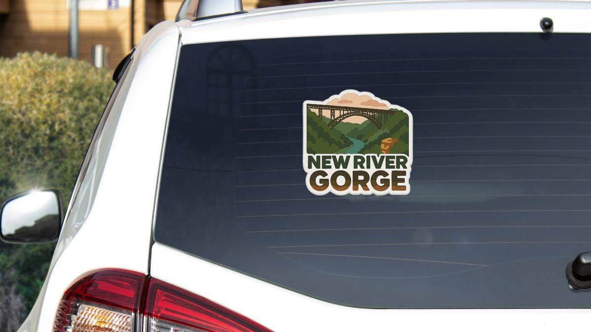 the rear window of a white car with a sticker on it that says "New River Gorge".