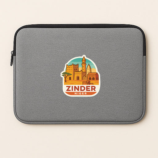 A gray laptop sleeve with a sticker depicting the city of Zindar, Niger.