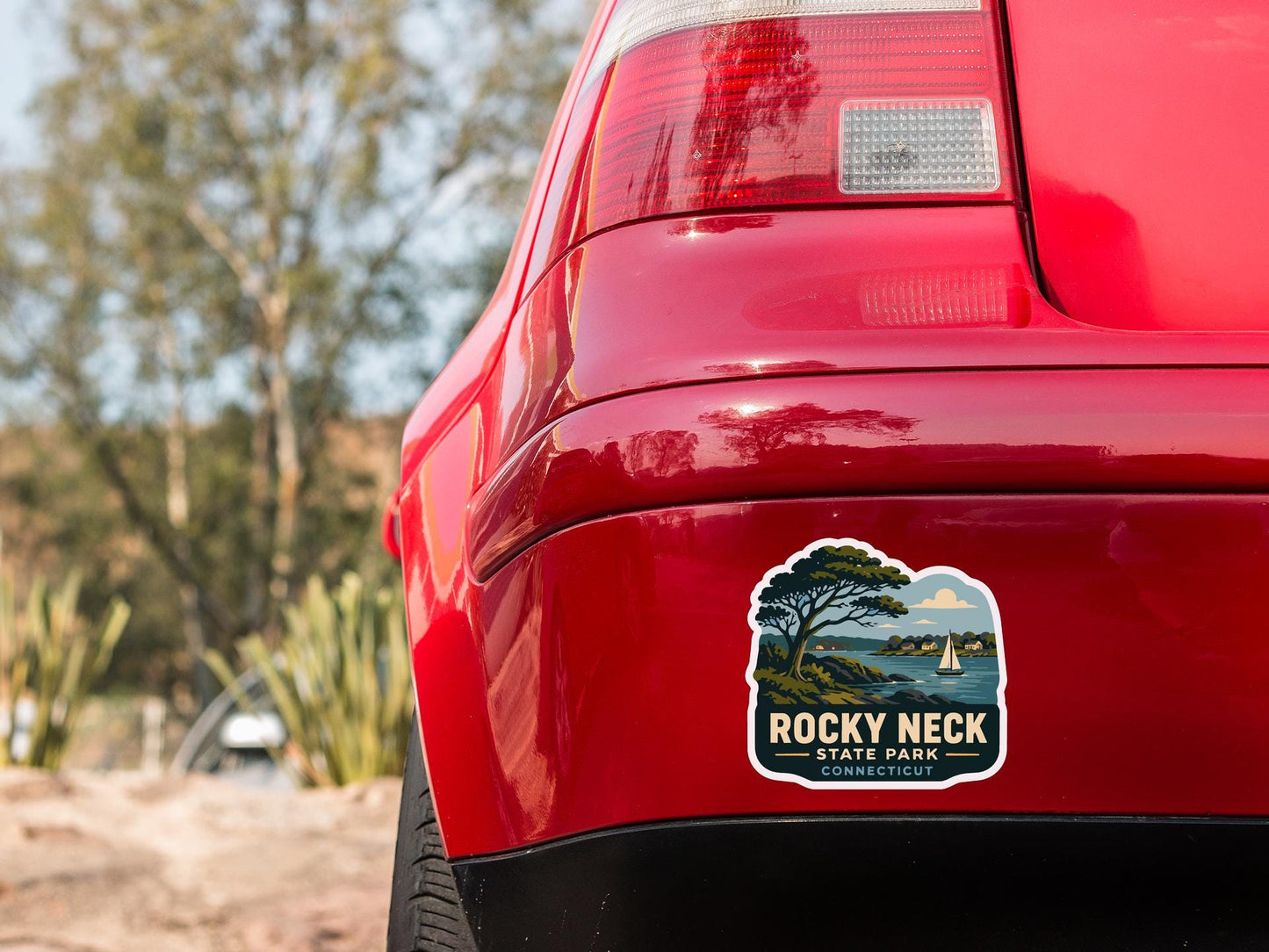 the rear end of a red car with a sticker on the back window that says "ROCKY NECK STATE PARK CONNECTICUT".
