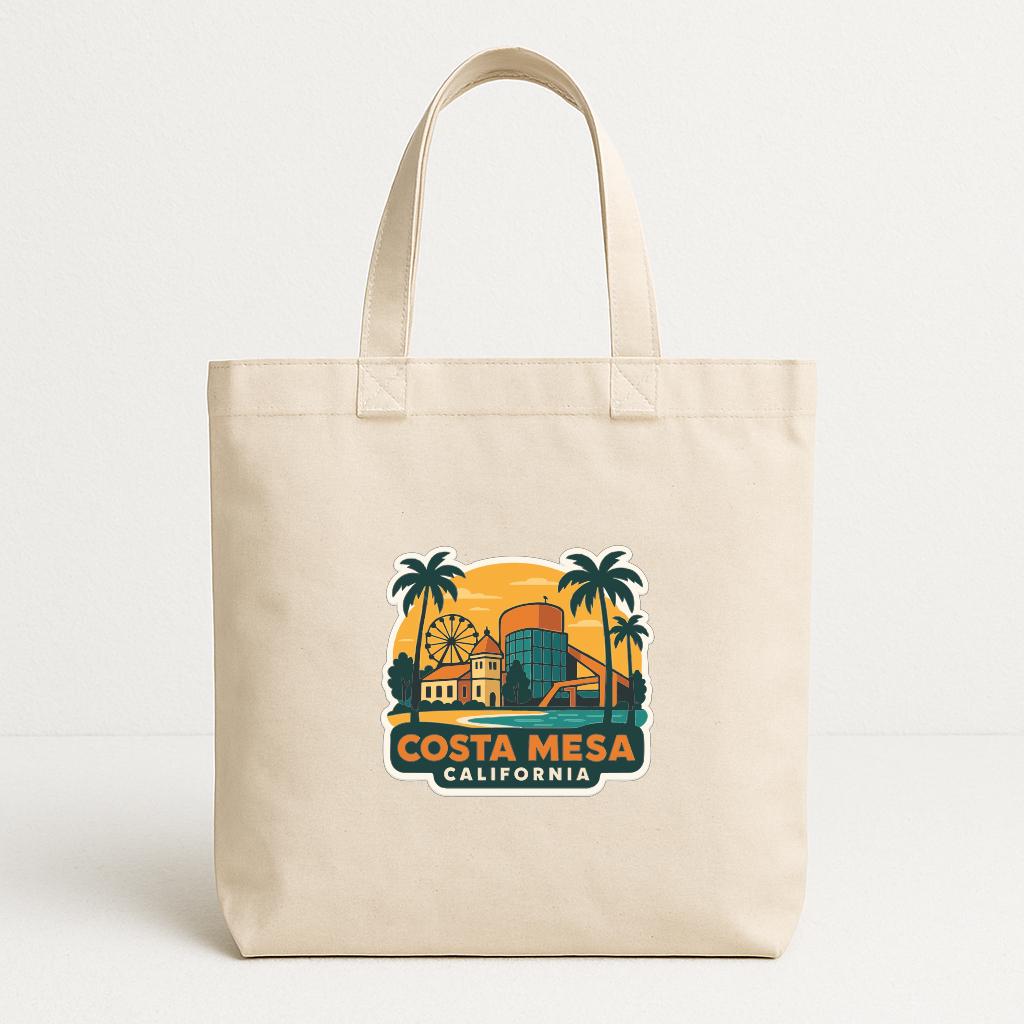 A beige tote bag with a printed design depicting a tropical scene with palm trees, a ferris wheel, and a building, along with the text "COSTA MESA CALIFORNIA".