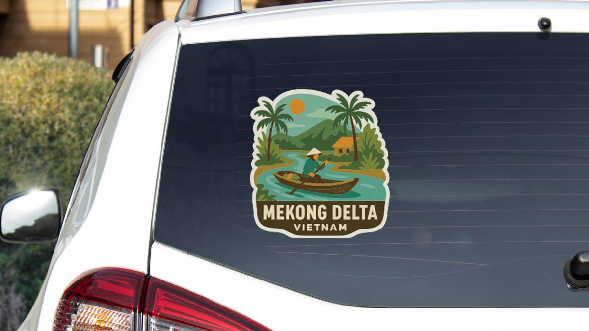 A sticker on the rear window of a car that features a tropical scene with a person in a boat, palm trees, and a house.