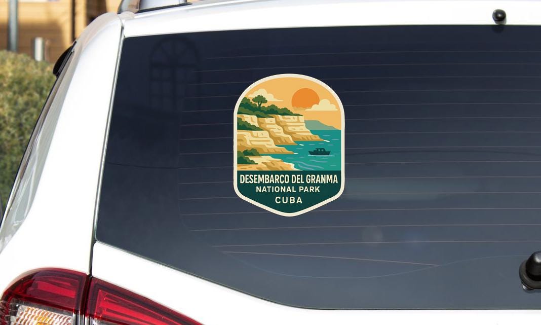 a sticker on the rear window of a vehicle, depicting a scenic landscape with a sunset over a body of water.