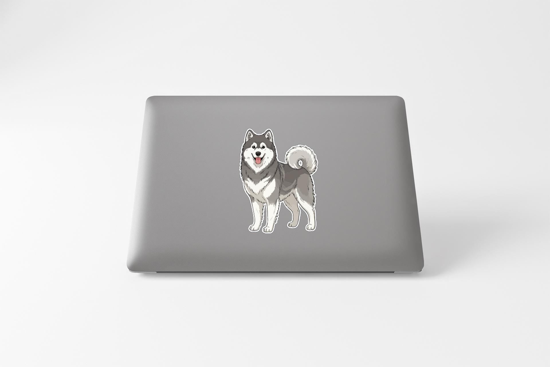 A gray laptop with a sticker of a husky dog on its cover.