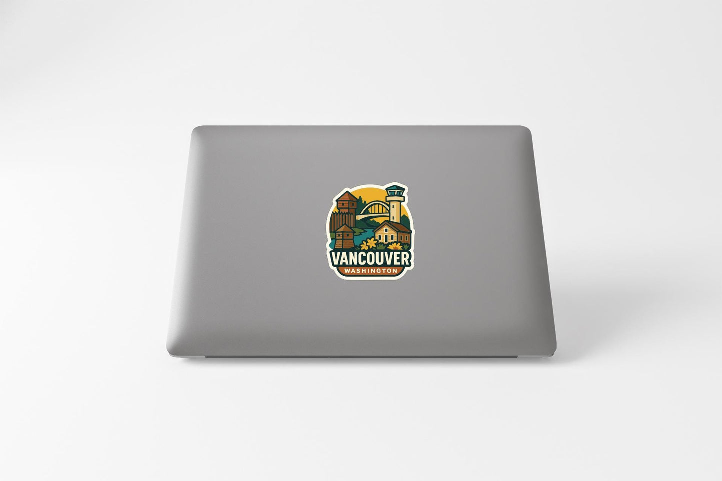 a sticker with a graphic of a cityscape and the text "VANCOUVER WASHINGTON" on the back of a laptop.
