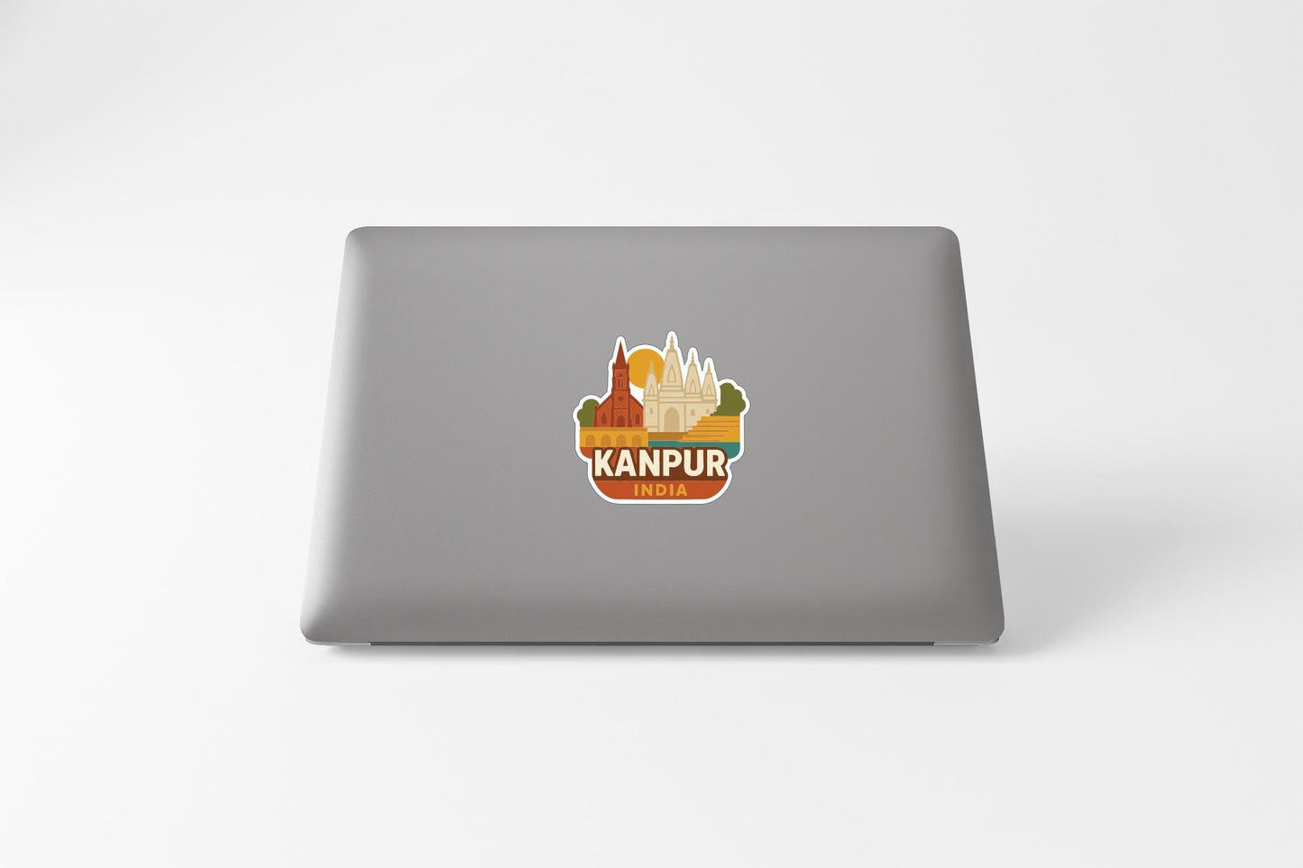 a sticker with a cityscape and the text "KANPUR INDIA" on the back of a laptop.