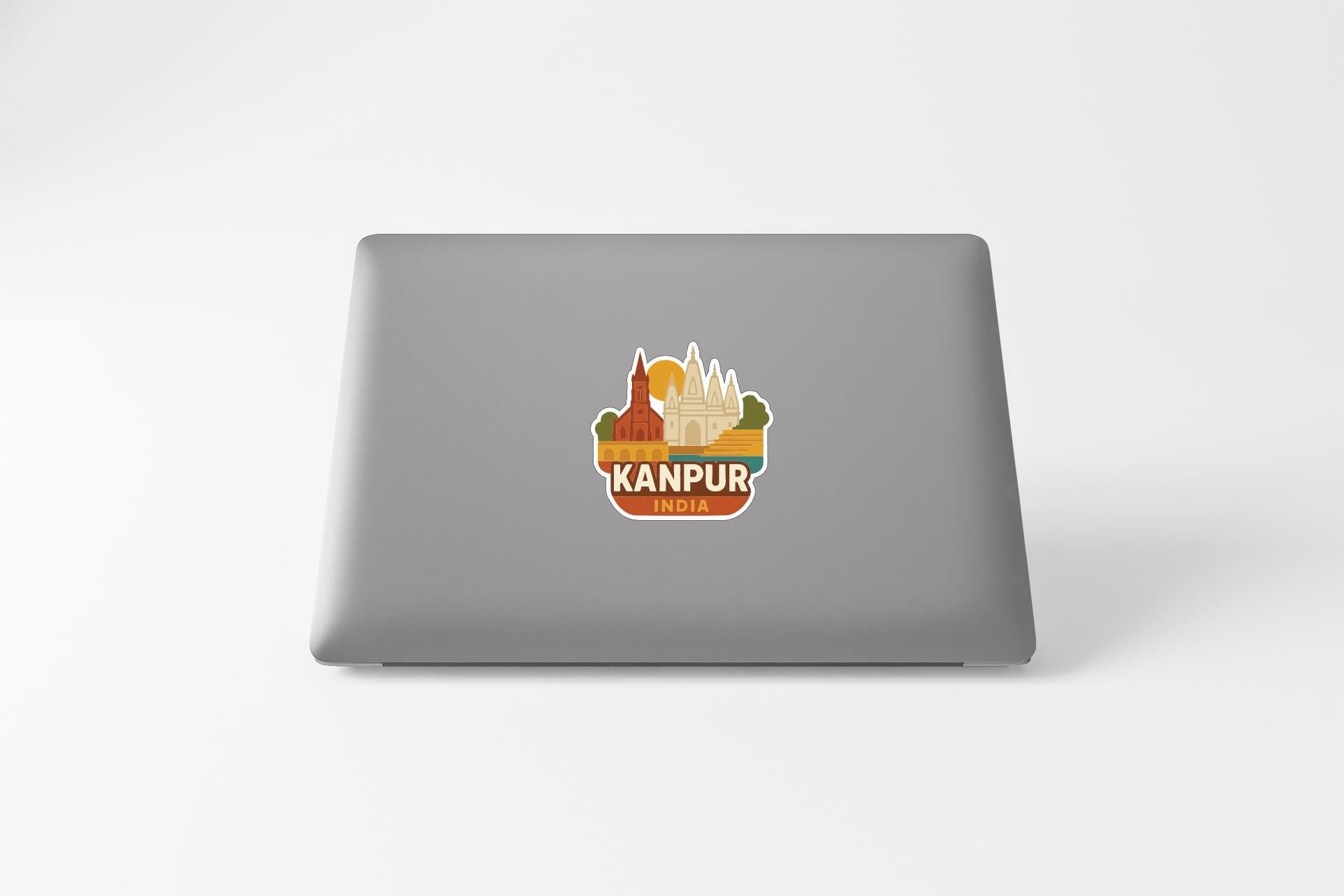 a sticker with a cityscape and the text "KANPUR INDIA" on the back of a laptop.