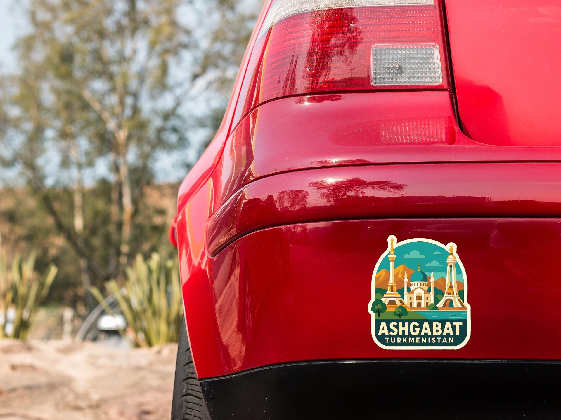 the rear end of a red car with a sticker on the trunk that says "ASHGABAT TURKMENISTAN".