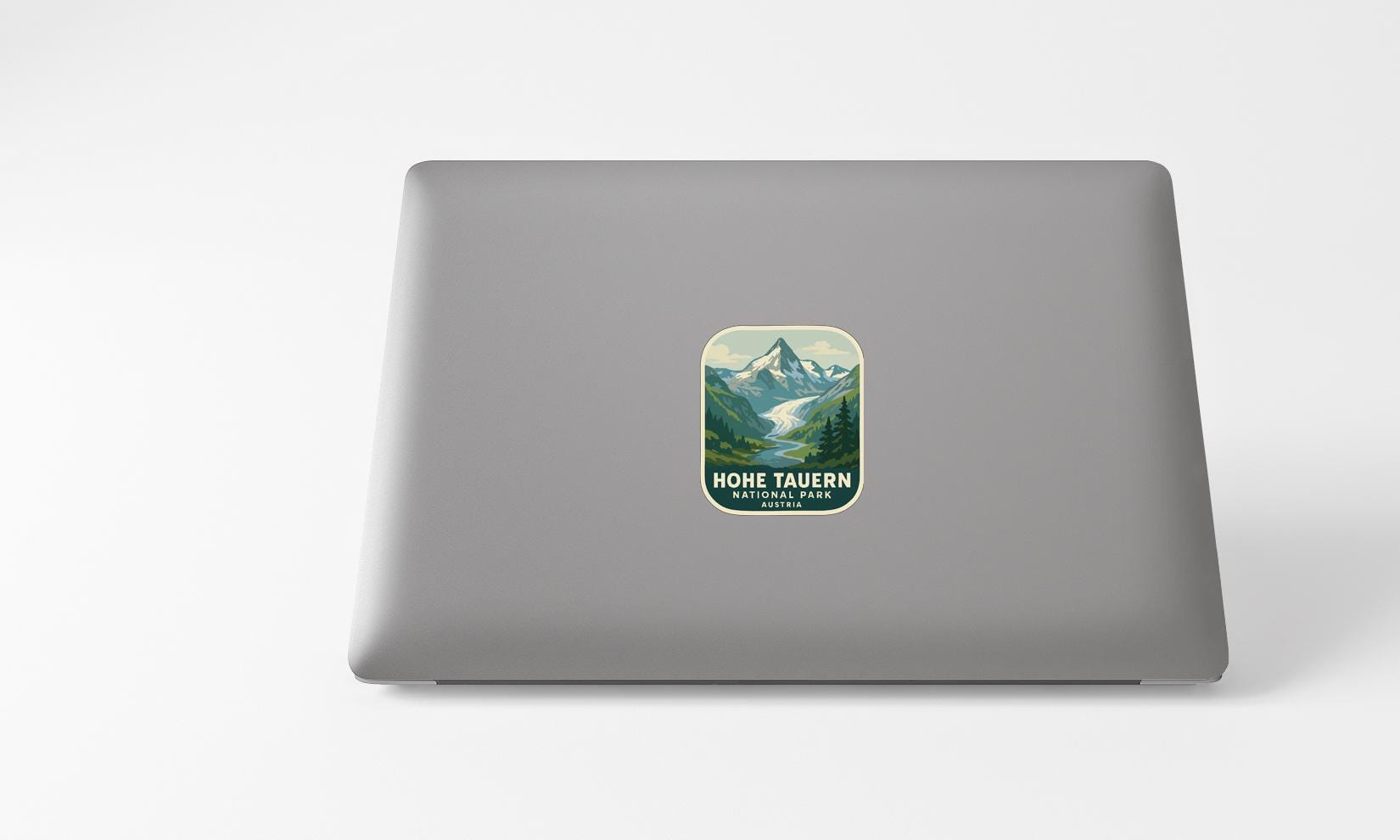 A sticker with a mountain landscape on a laptop.