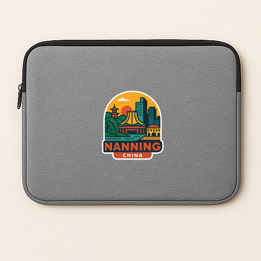 A gray laptop sleeve with a colorful sticker depicting a city skyline and the text "NANNING CHINA".