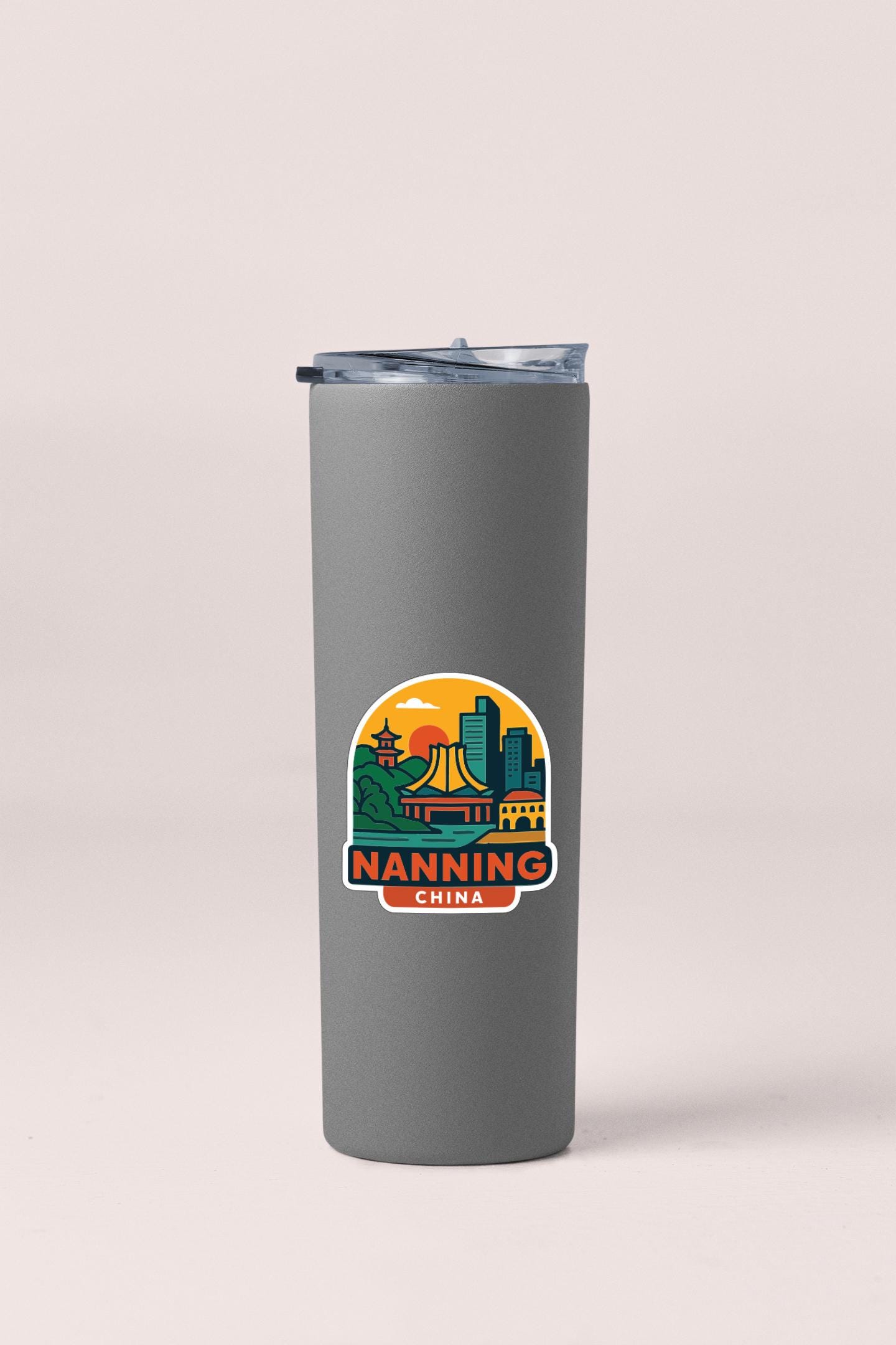 A gray insulated tumbler with a sticker depicting a cityscape and the text "NANNING CHINA".