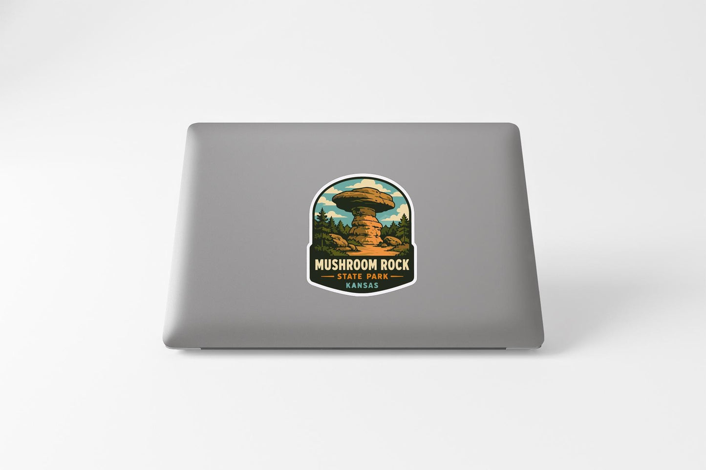 A sticker on the back of a laptop, depicting a mushroom rock formation in Kansas.