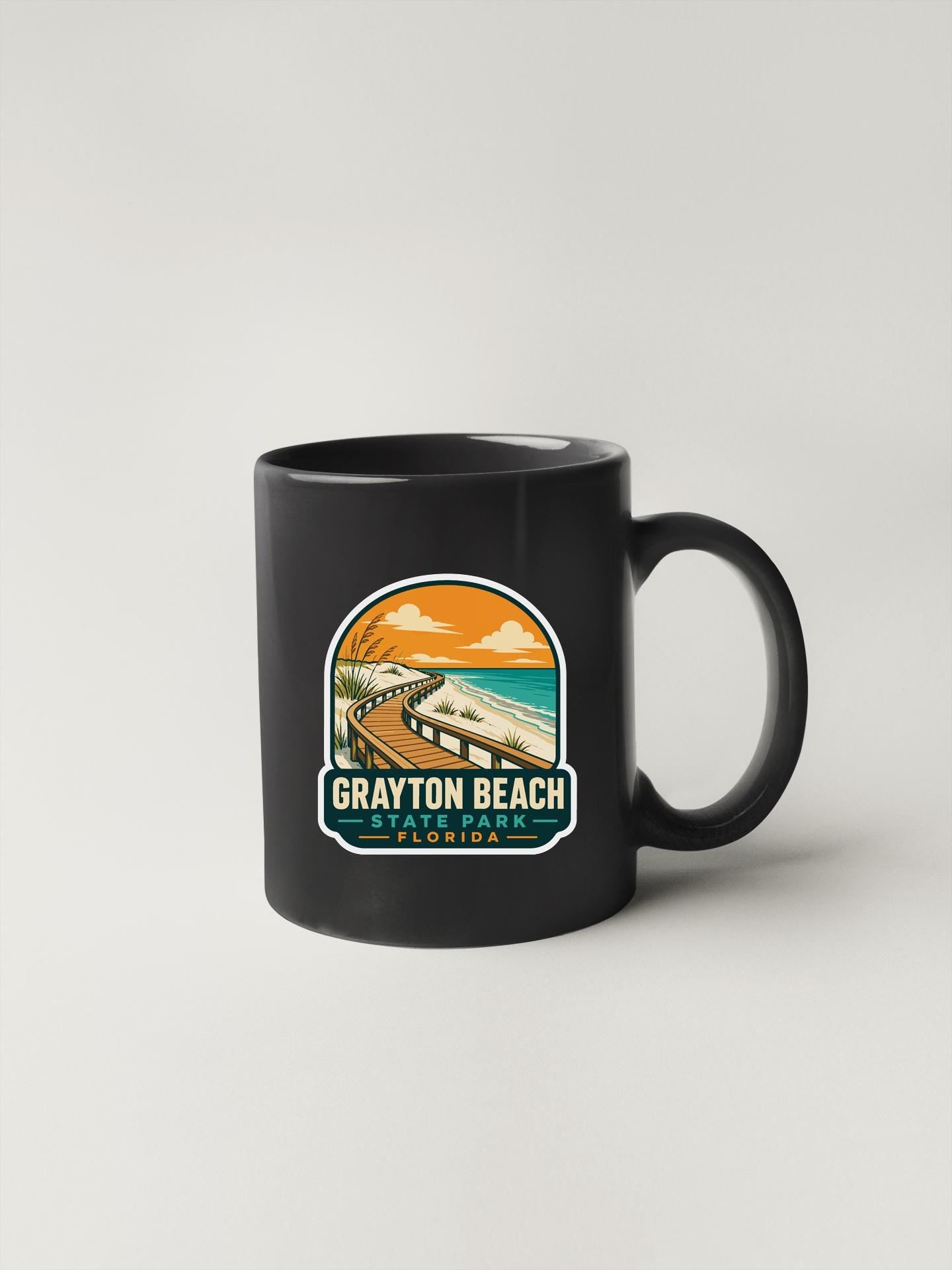 A black coffee mug with a graphic design depicting a beach scene and the text "Grayson Beach, Florida" printed on it.