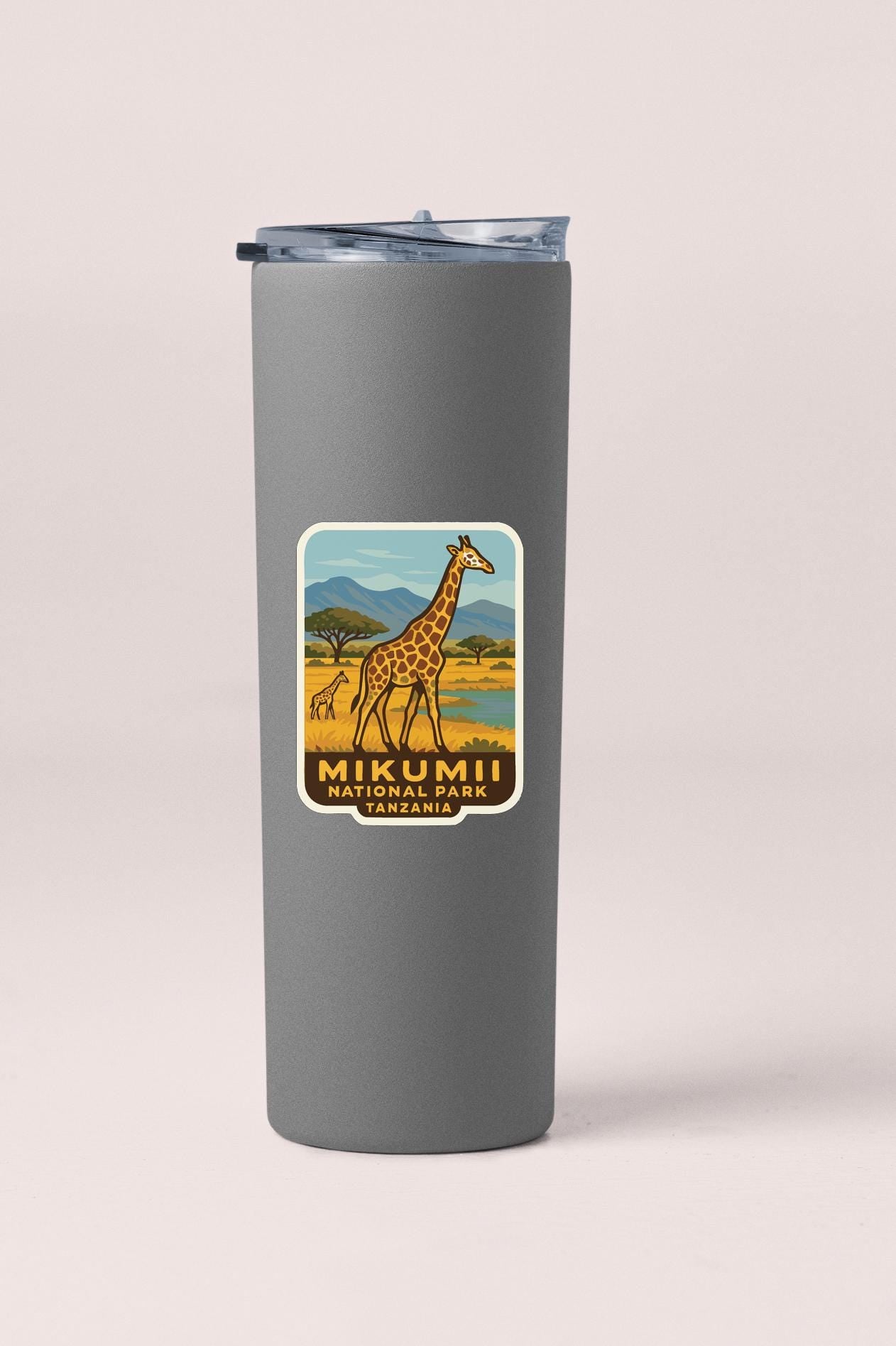 A gray tumbler with a label that features a giraffe and the text "Mikumii National Park Tanzania".