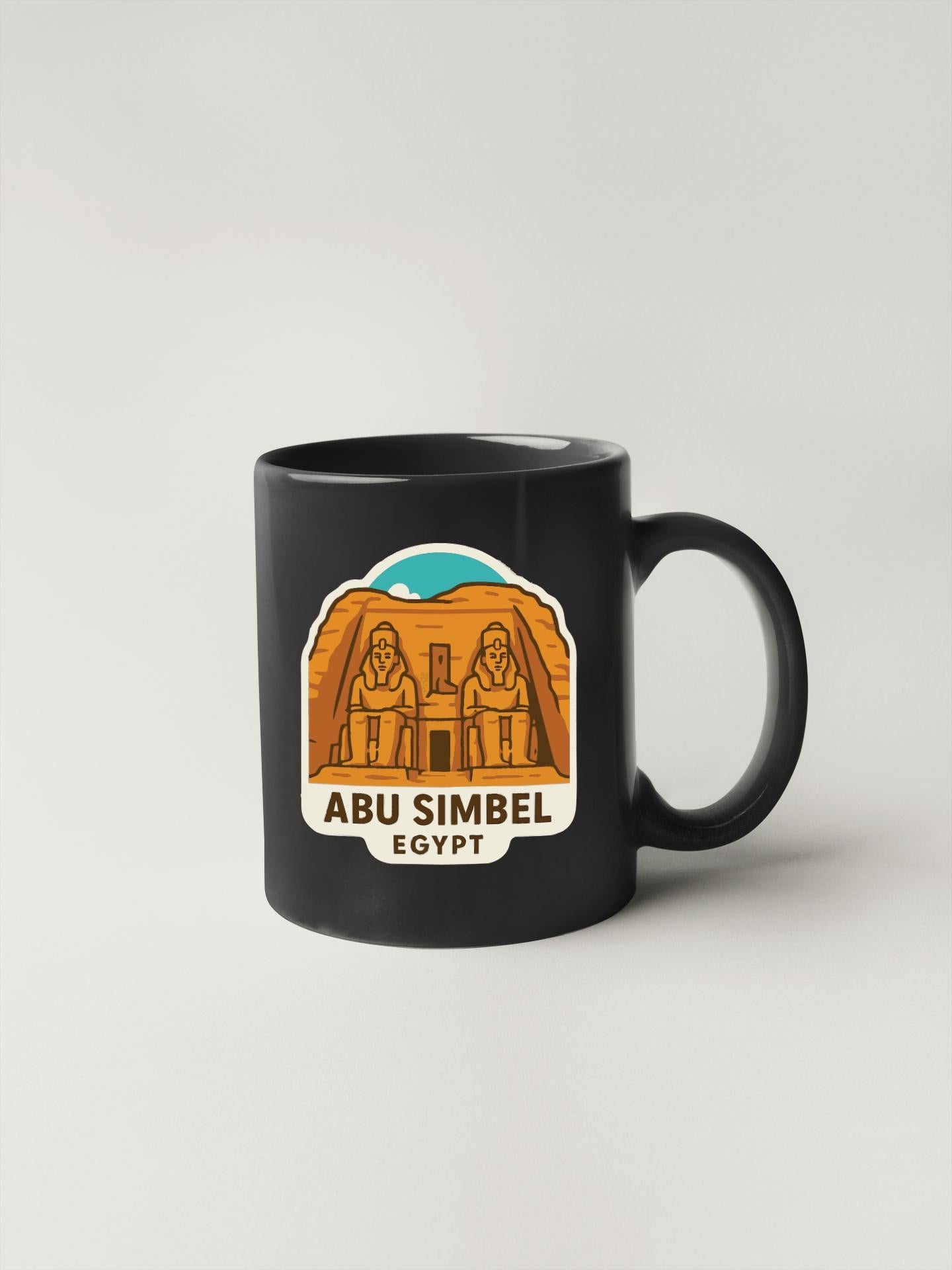 A black coffee mug with a graphic design depicting the Abu Simbel temple in Egypt.