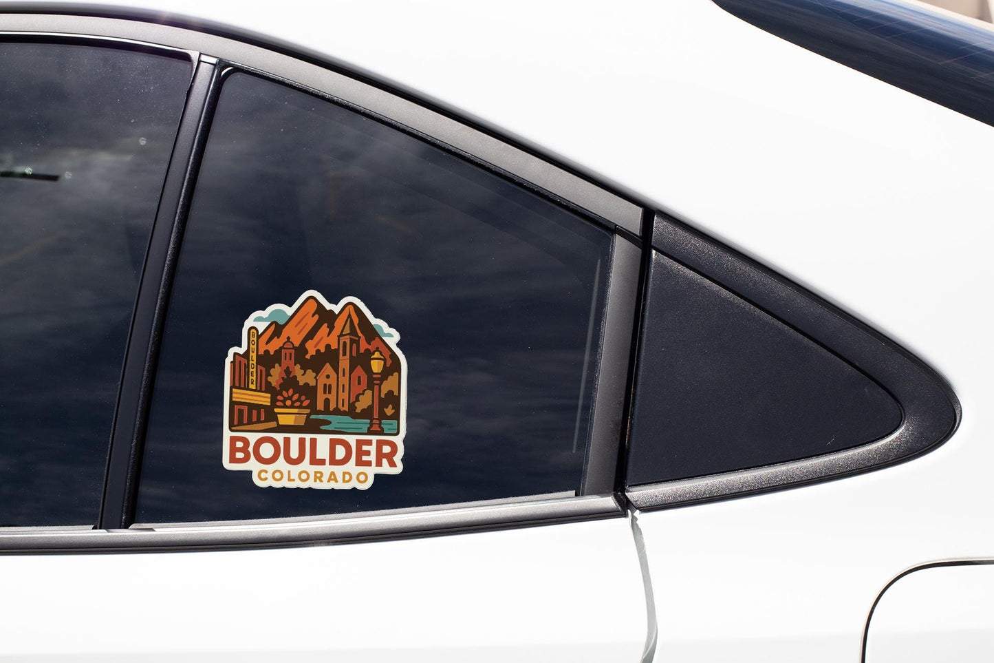 A sticker on the side of a car window, depicting a mountain landscape with the text "Boulder, Colorado" printed on it.