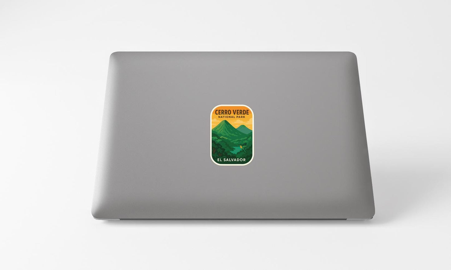 A sticker on the back of a laptop, depicting a mountain landscape with a yellow and green color scheme.