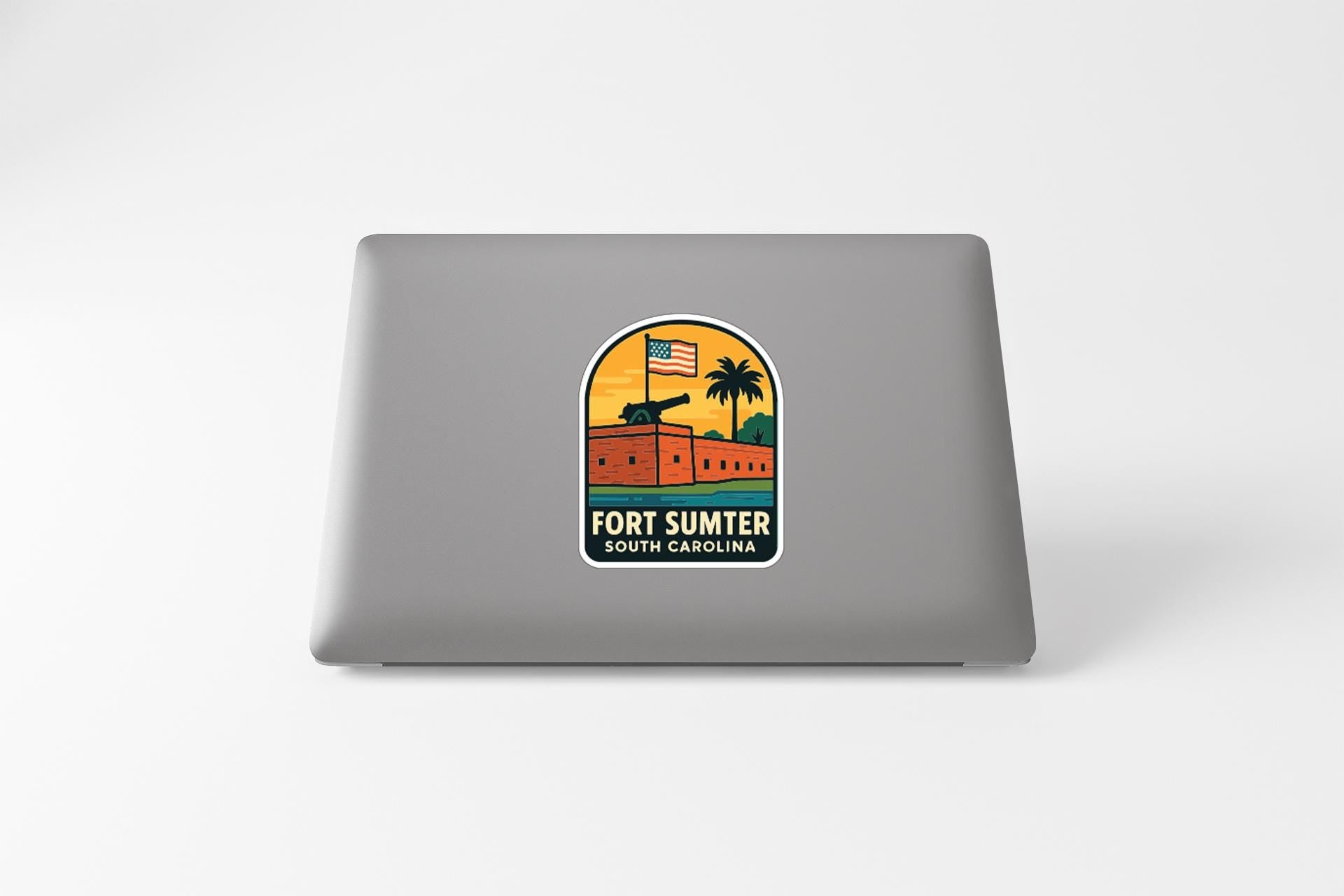 A sticker on the back of a laptop, depicting a tropical scene with a building, palm tree, and American flag.