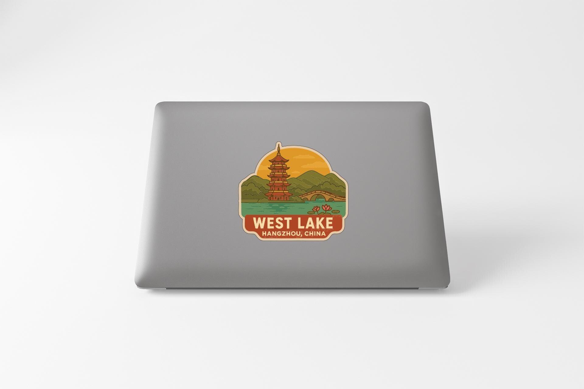 A sticker on the back of a laptop, depicting a pagoda and a lake, with the text "WEST LAKE" and "HANZHIL CHINA" below it.
