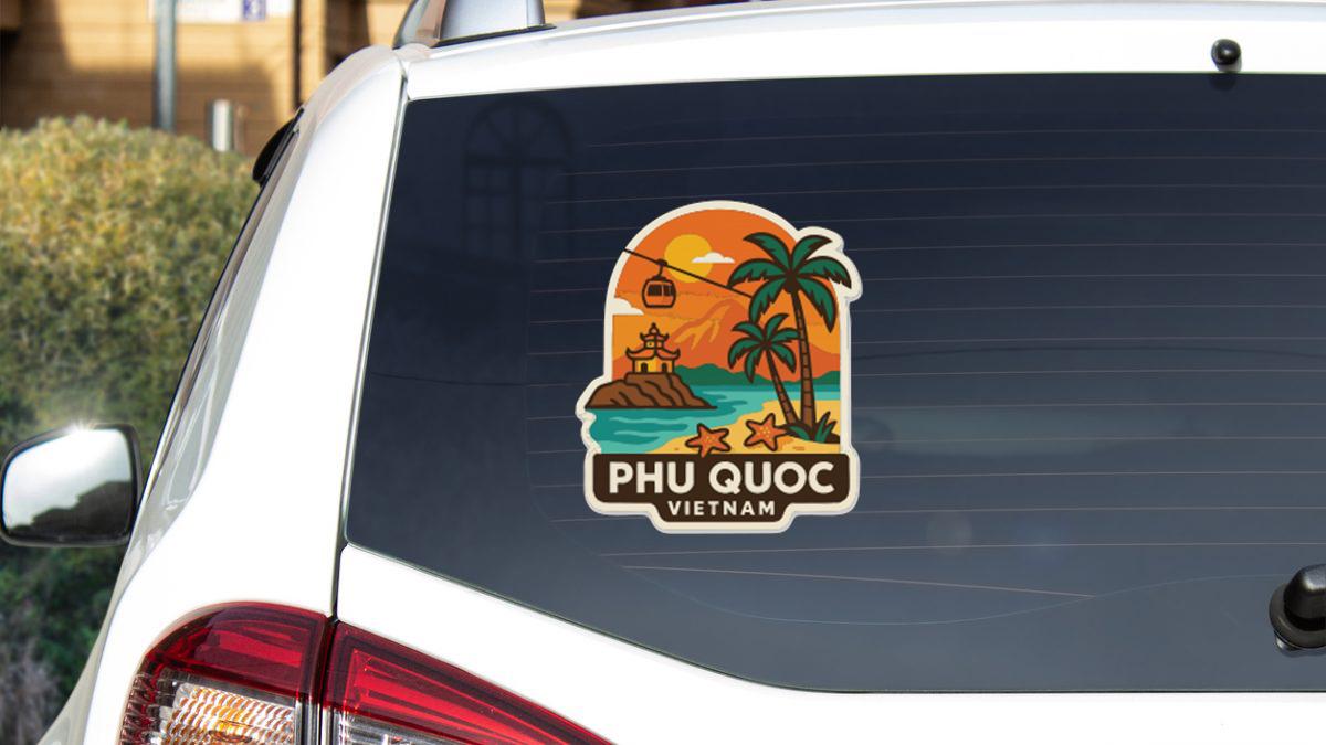 A sticker on the rear window of a white car, depicting a tropical beach scene with palm trees, a temple, and a sunset.