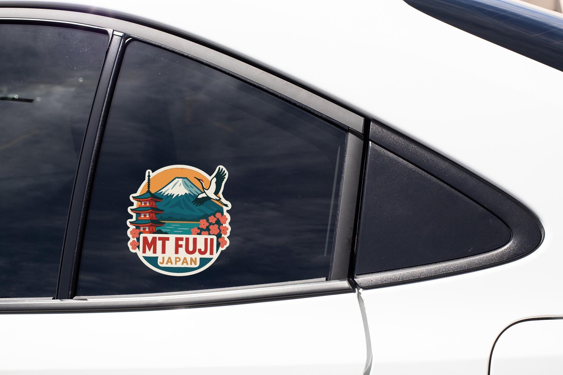 A sticker on the side of a car window, featuring a mountain and a temple, with the text "MT FUJI JAPAN".