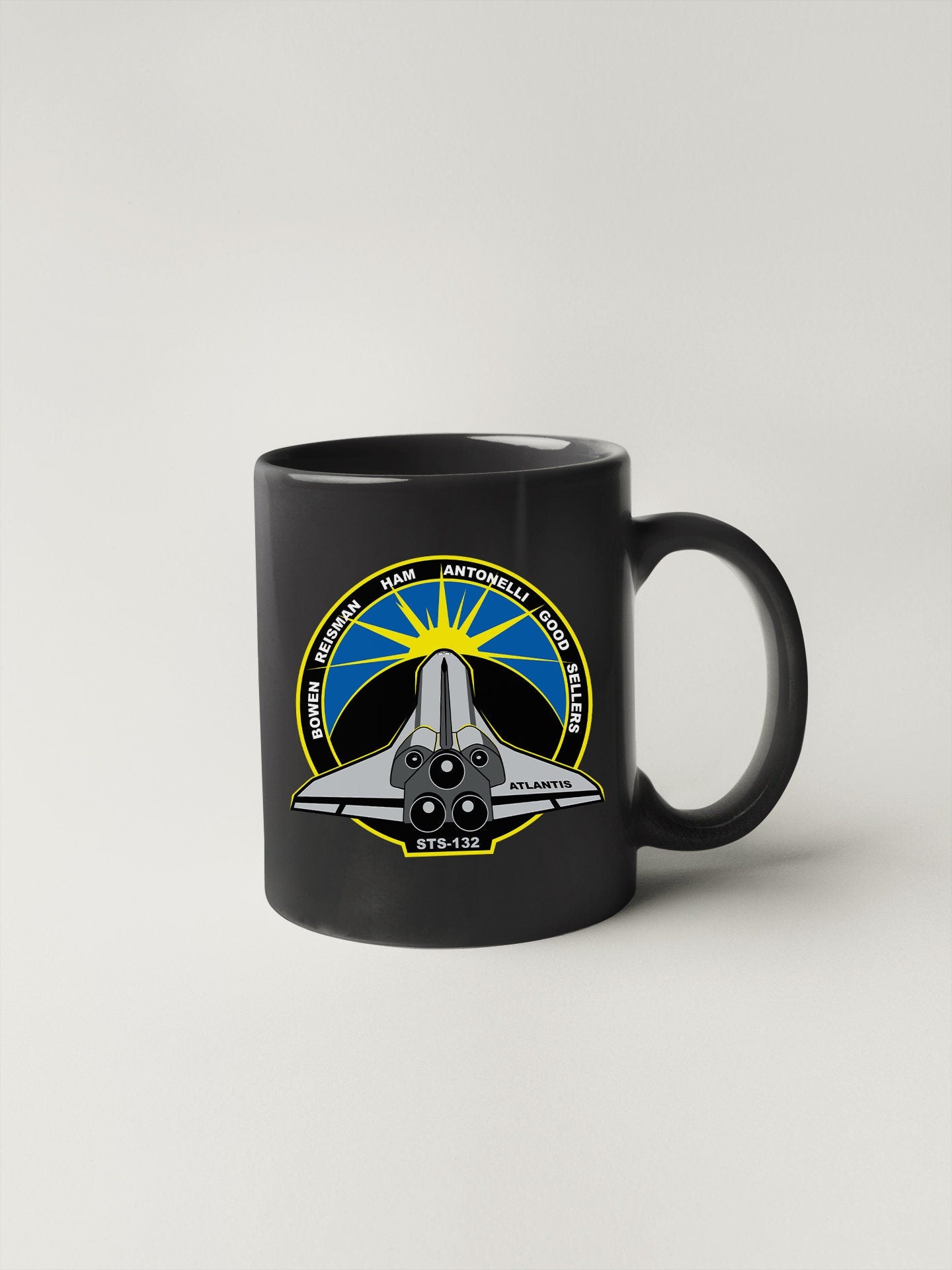 a black coffee mug with a space shuttle on it