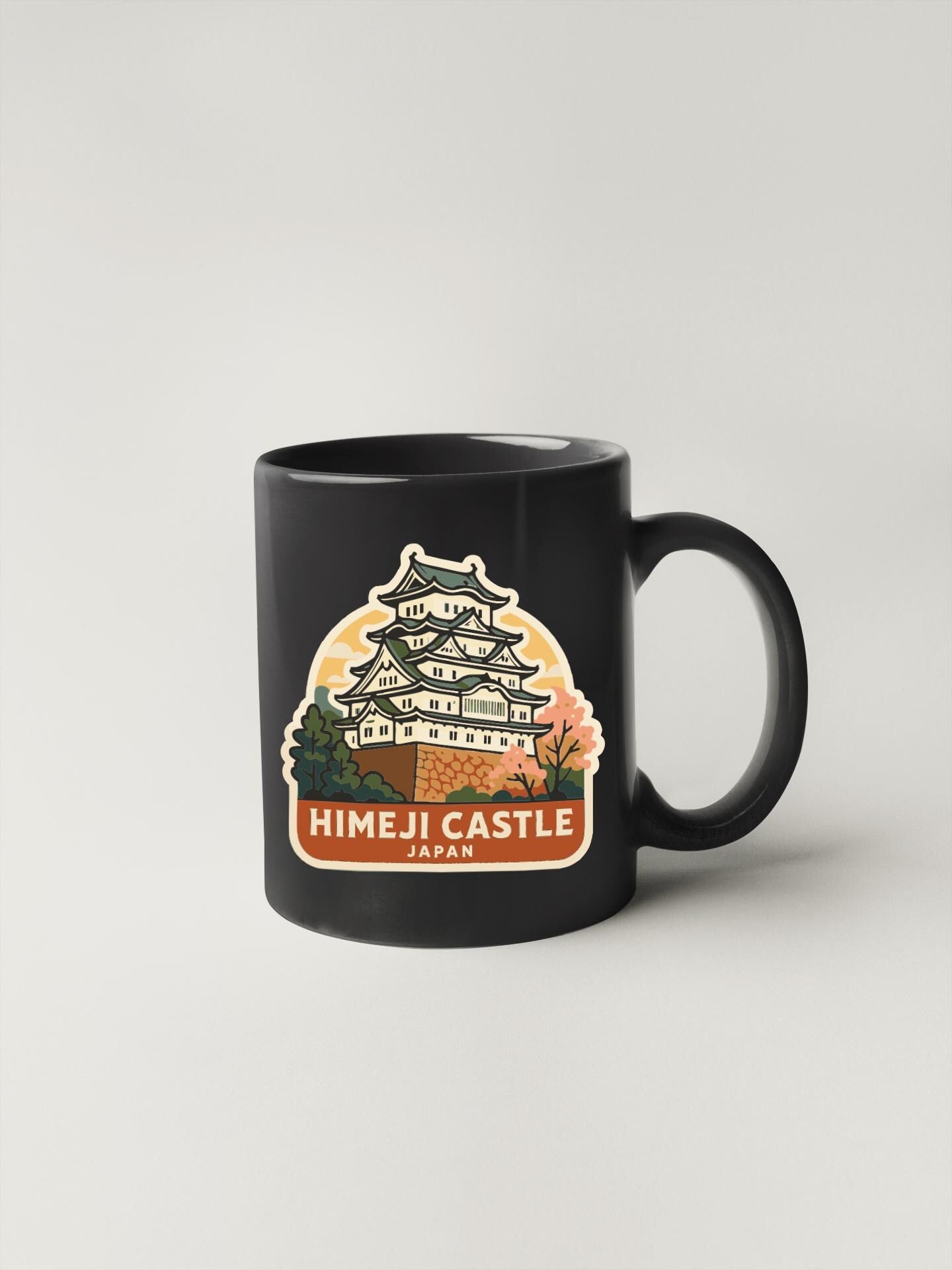 A black coffee mug with a sticker depicting the Himeji Castle in Japan.