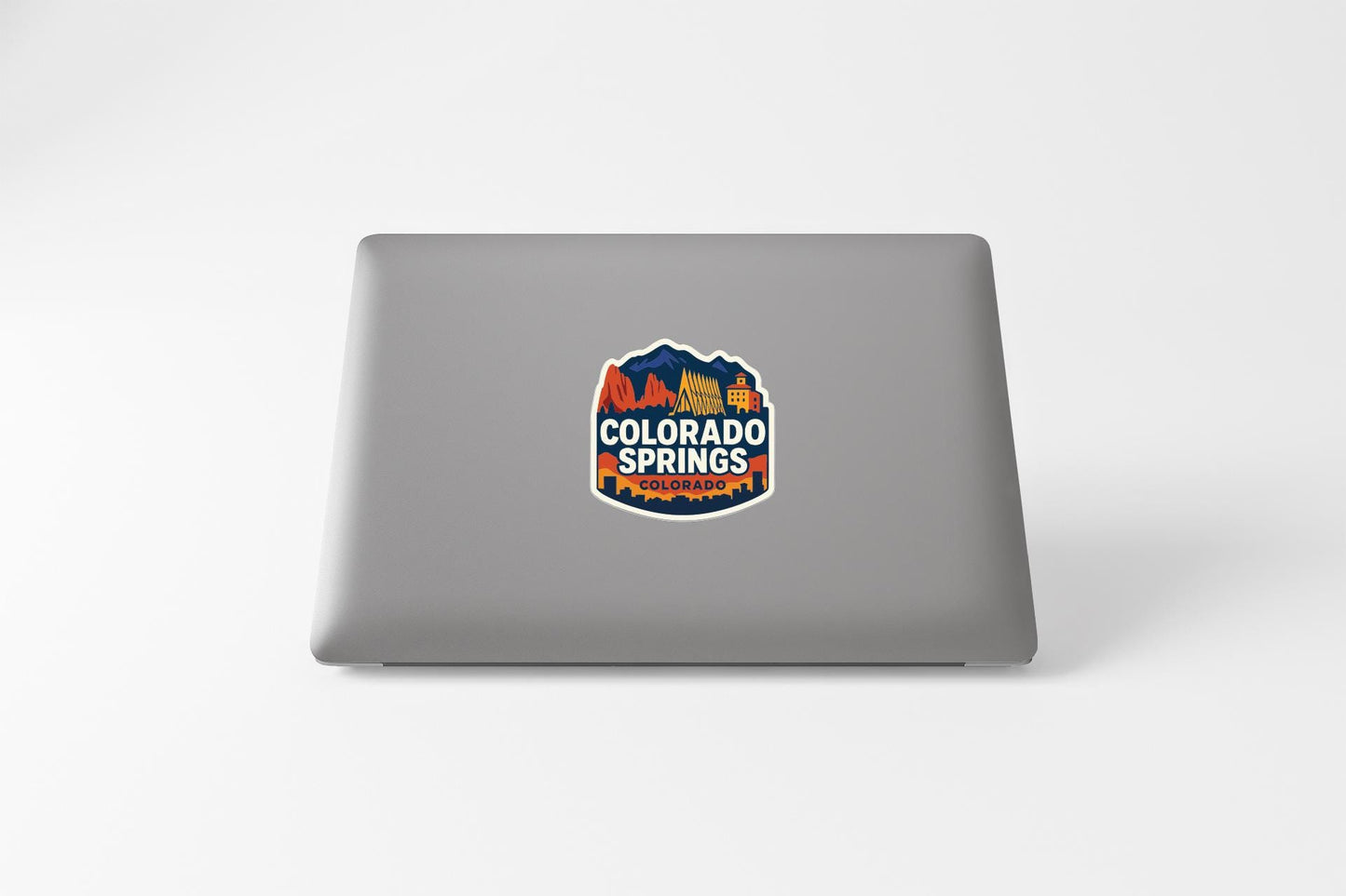 a sticker with the text "COLORADO SPRINGS" on a grey laptop.
