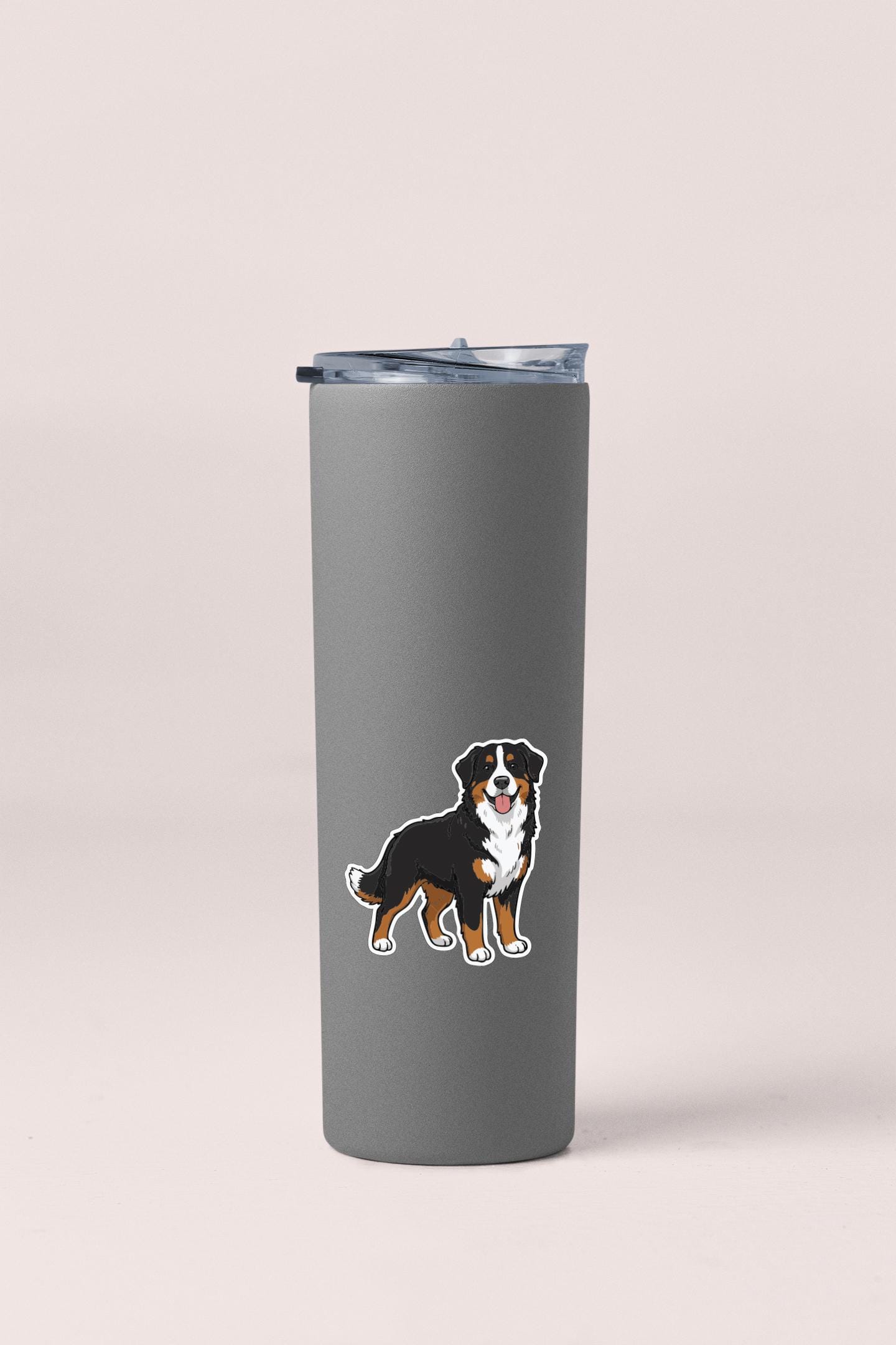 A gray insulated tumbler with a sticker of a dog on it.
