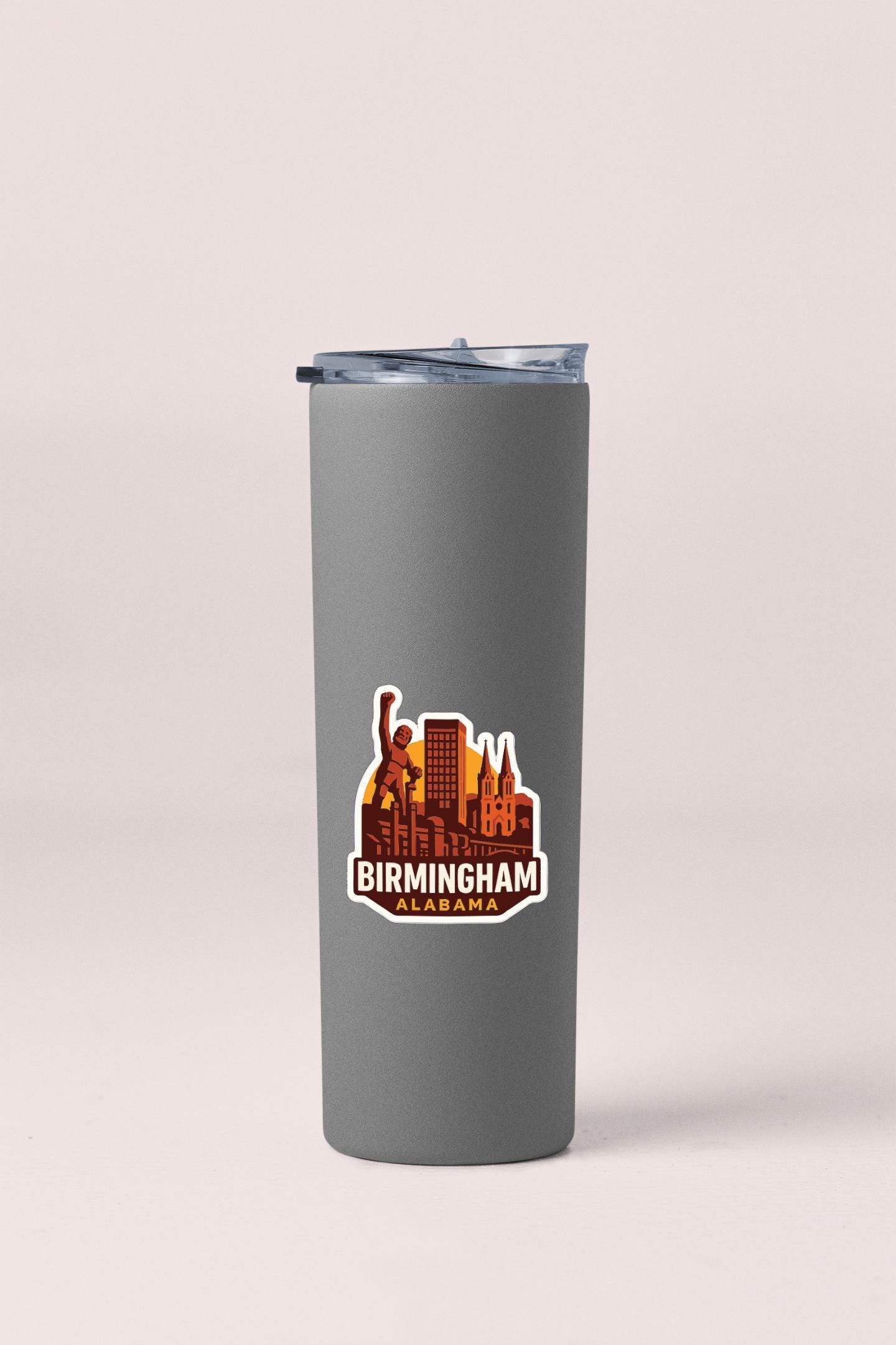 A gray insulated tumbler with a printed design of the Birmingham skyline in the center.