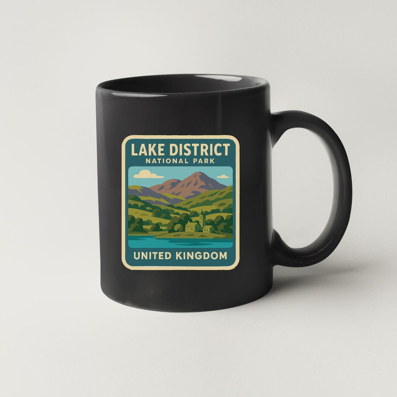 A black coffee mug with a label that says "LAKED DISTRICT NATIONAL PARK UNITED KINGDOM".
