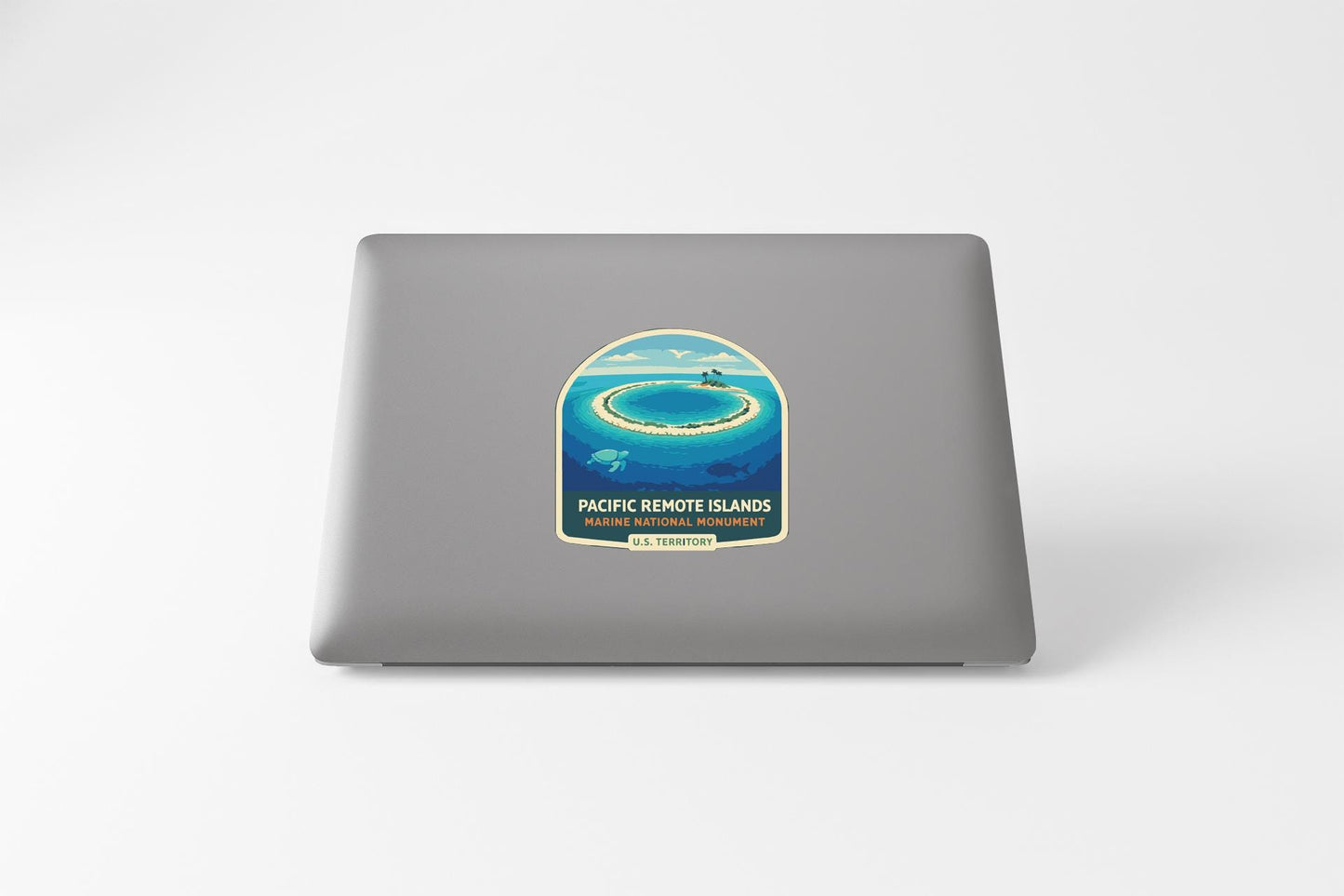 a sticker on the back of a laptop that depicts a tropical island surrounded by the ocean.