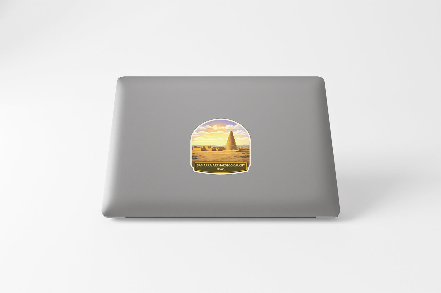a sticker on a laptop with a desert landscape and a tower in the background.