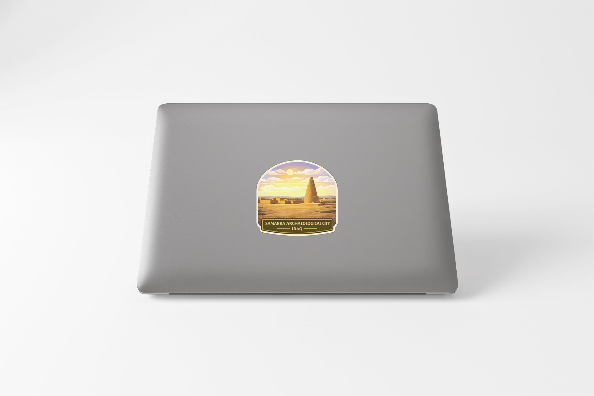 a sticker on a laptop with a desert landscape and a tower in the background.