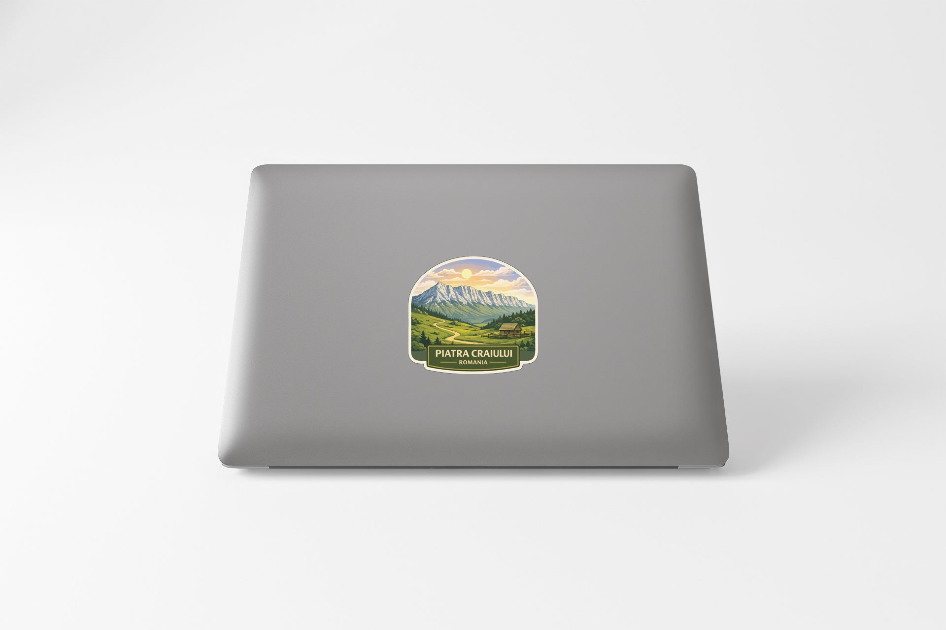 a sticker with a mountain landscape on the back of a laptop.