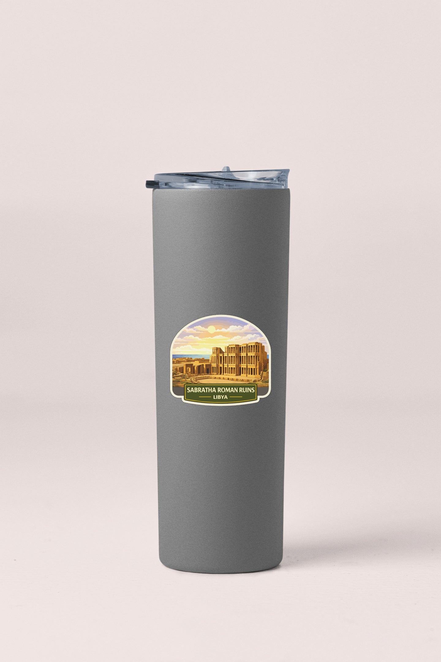 A gray insulated tumbler with a lid and a sticker depicting a building and a sunset.