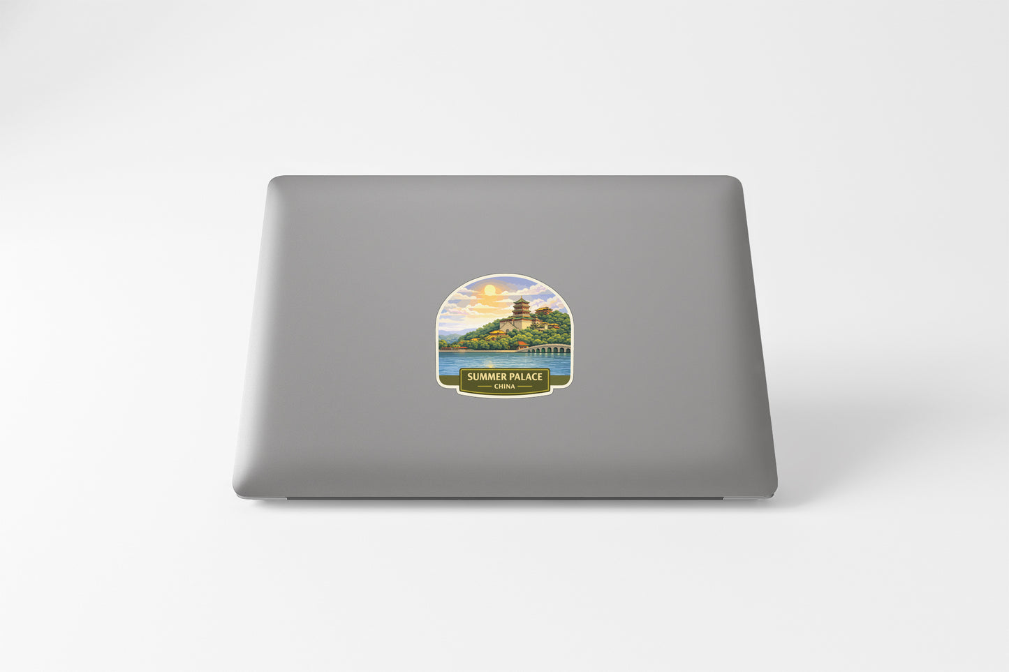 A sticker on the back of a laptop, depicting a scenic landscape with a temple in the distance.