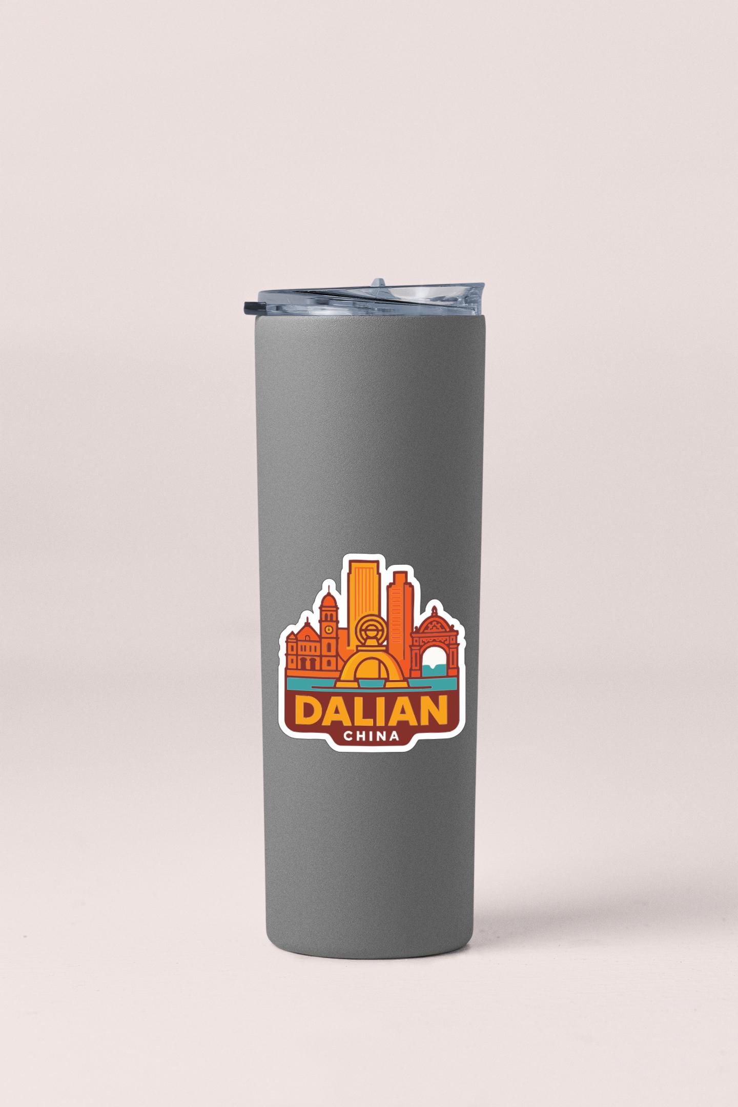 A gray insulated tumbler with a sticker depicting the city of Dalian, China.