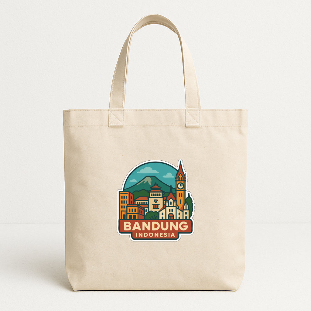 A beige tote bag with a graphic design depicting a cityscape and the text "BANDUNG INDONESIA" printed on it.
