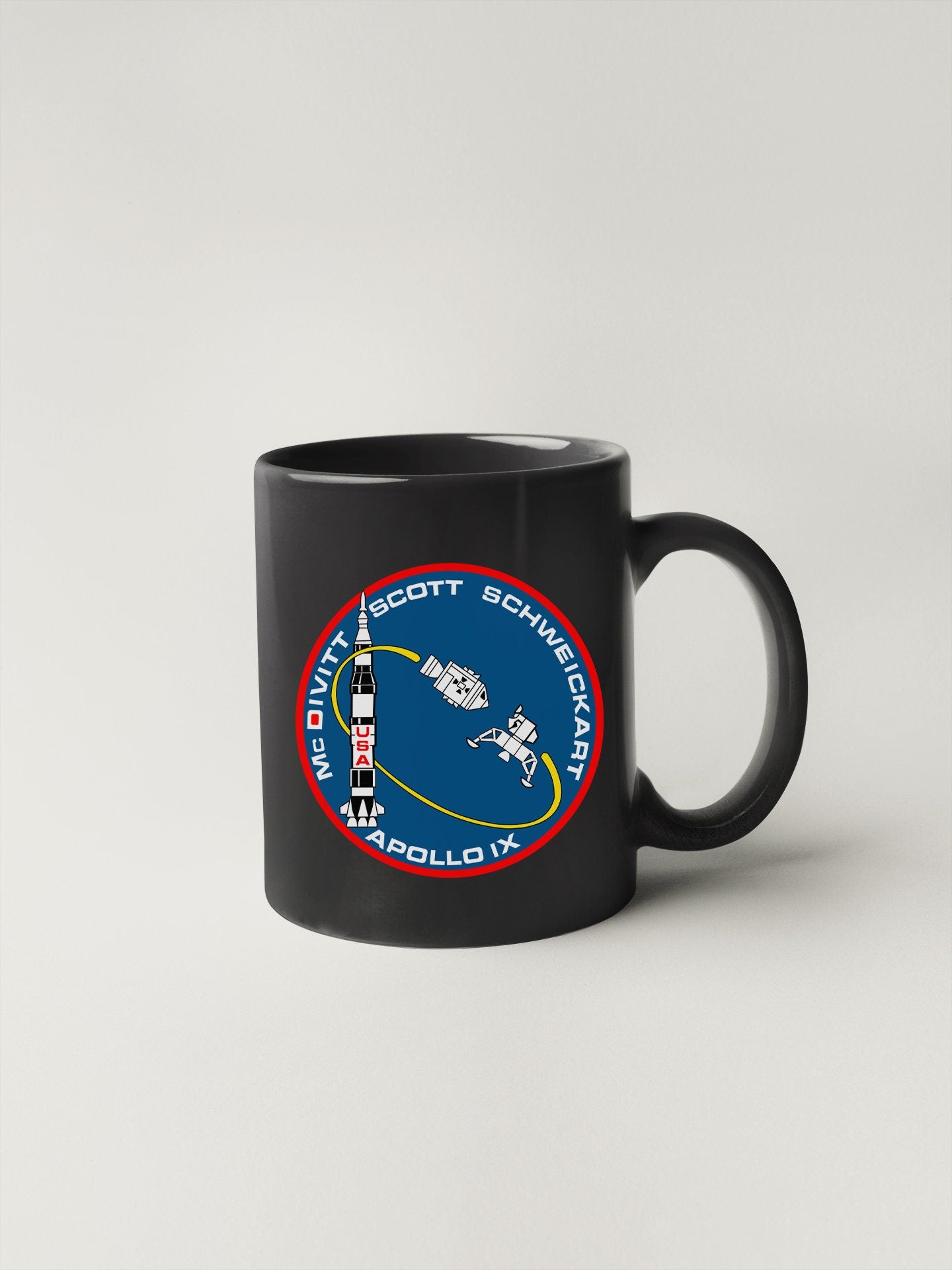a black coffee mug with a nasa emblem on it