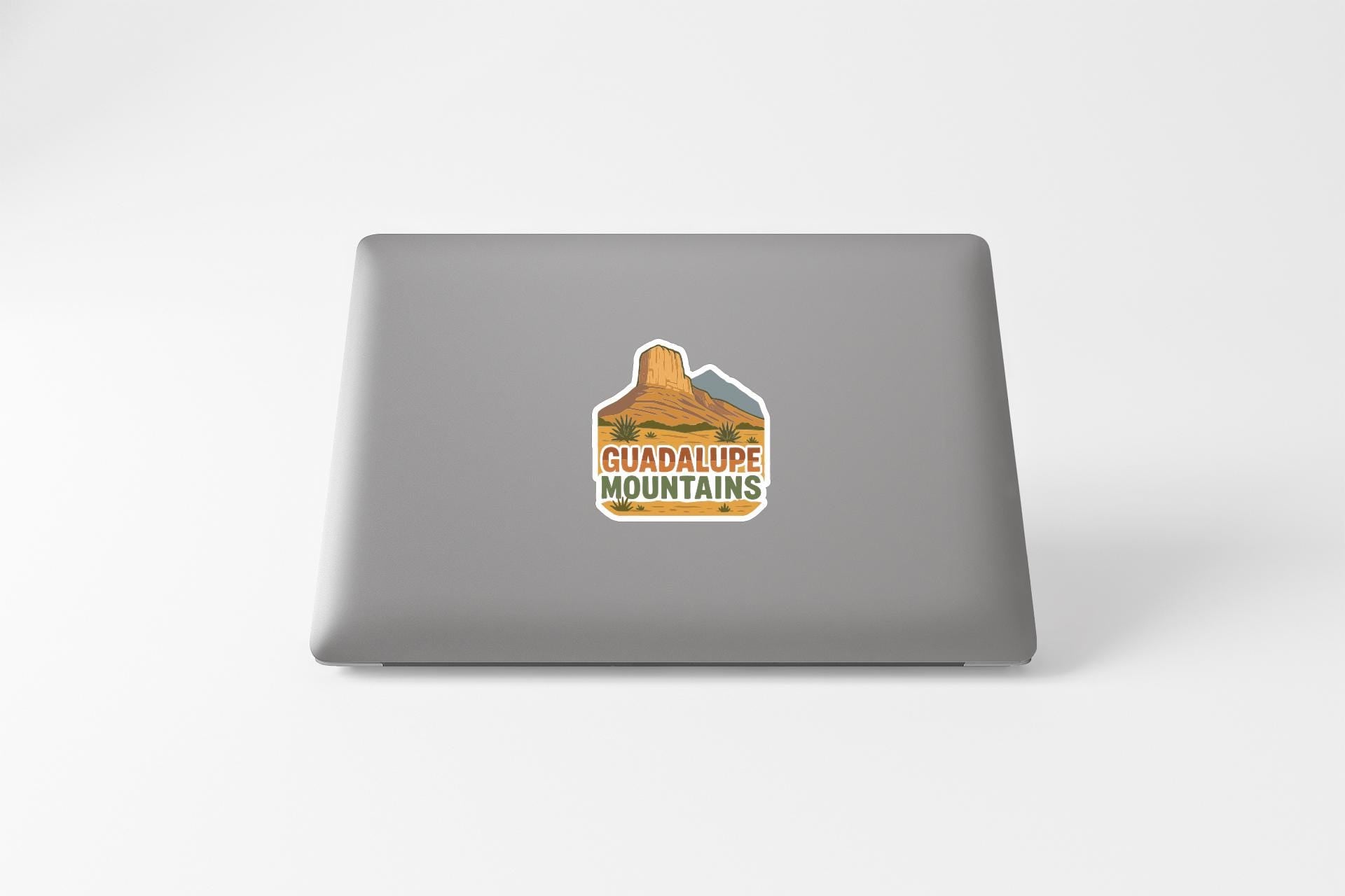 a sticker with a mountain and the text "GUADALUPE MOUNTAINS" on the back of a laptop.
