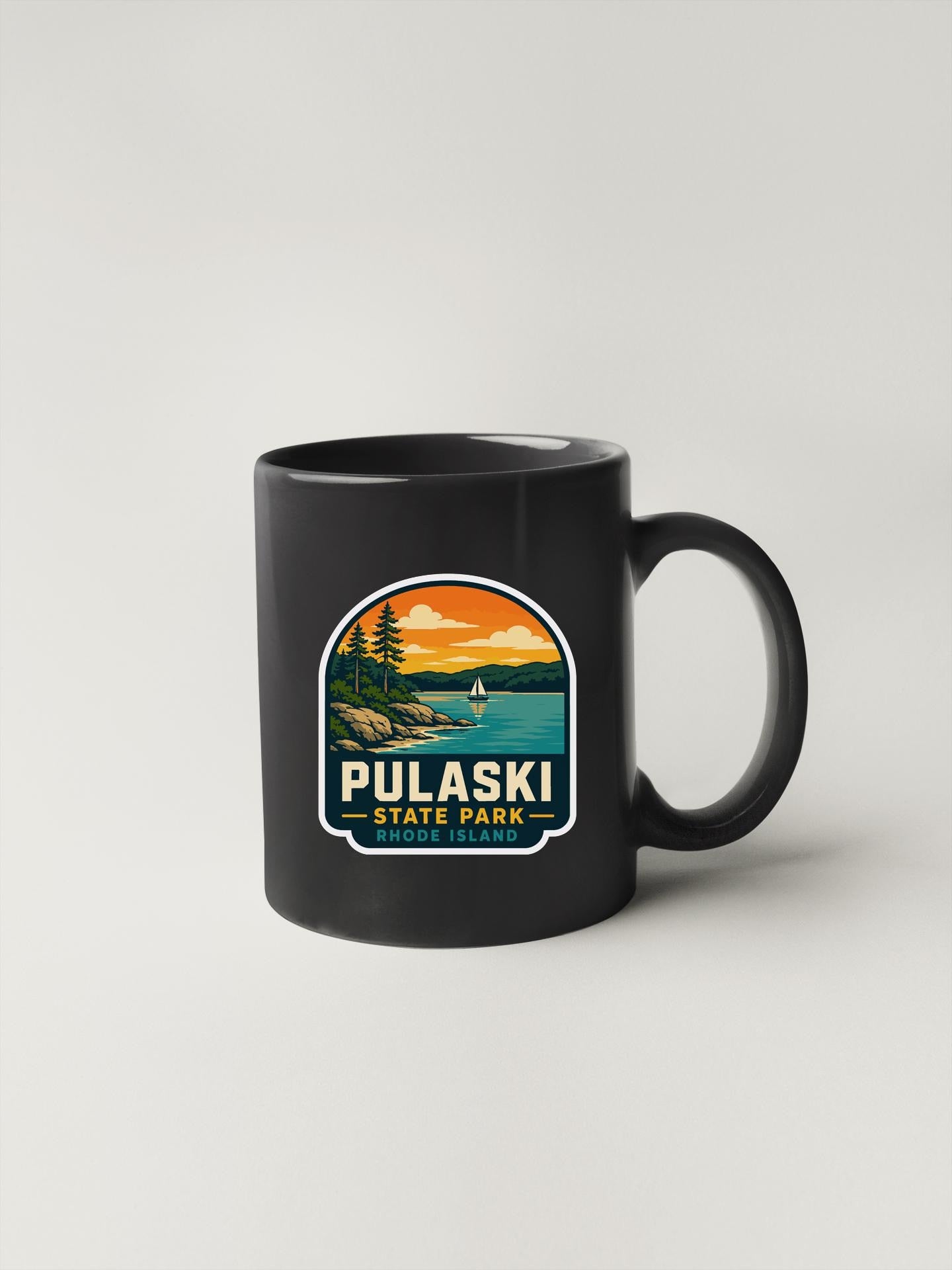 A black coffee mug with a graphic design depicting a scenic landscape with a lake, mountains, and a sailboat.