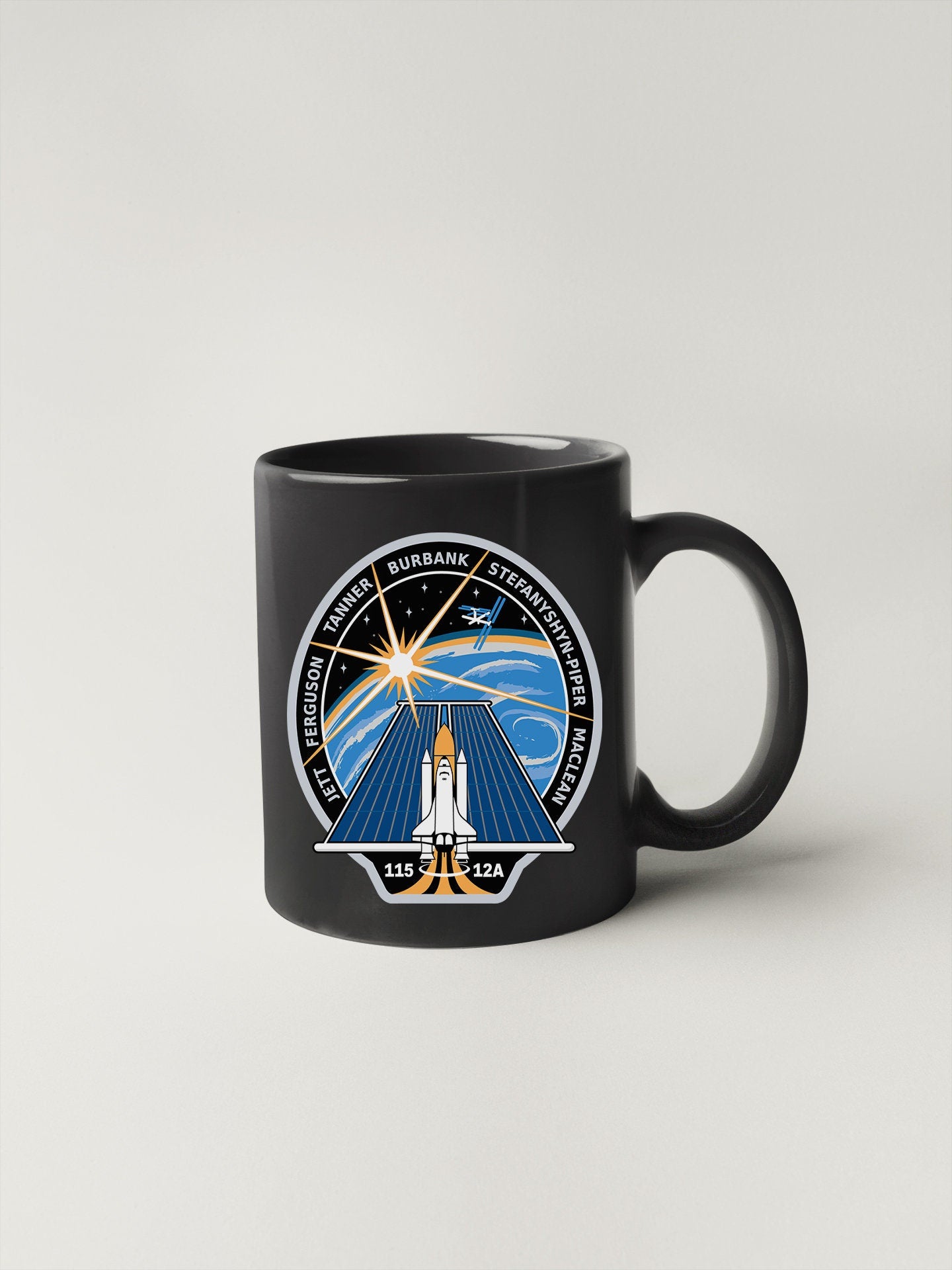 a black coffee mug with a space shuttle on it