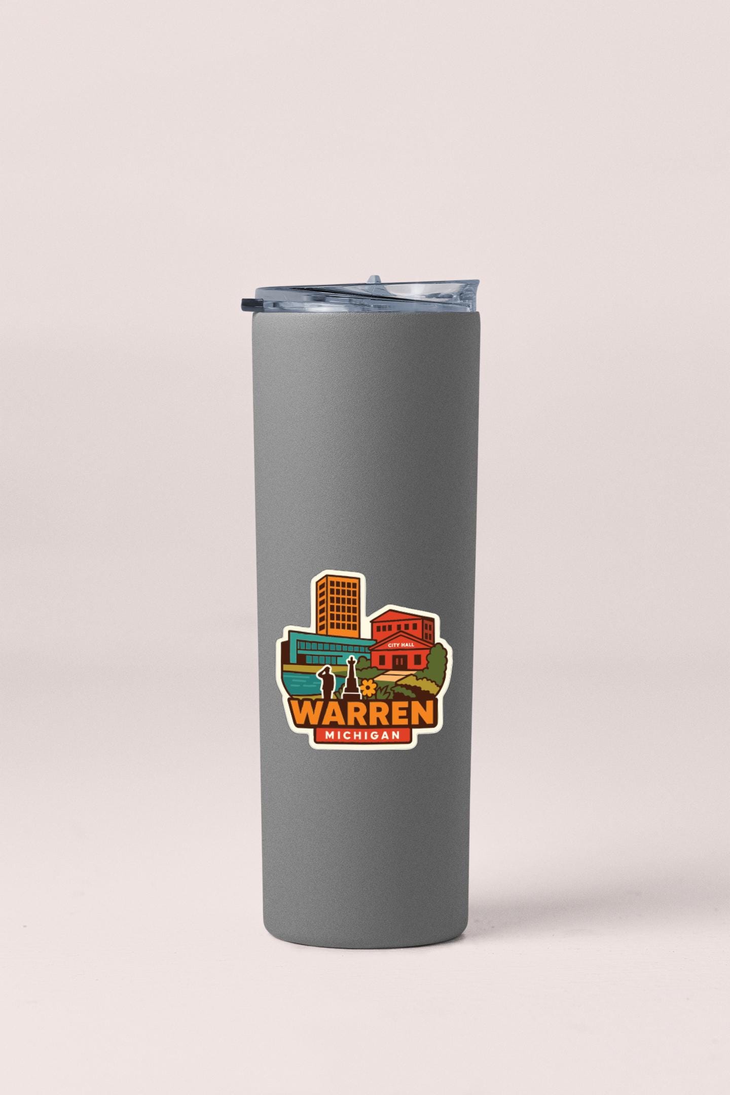 A gray insulated tumbler with a sticker depicting a cityscape and the text "WARREN MICHIGAN".