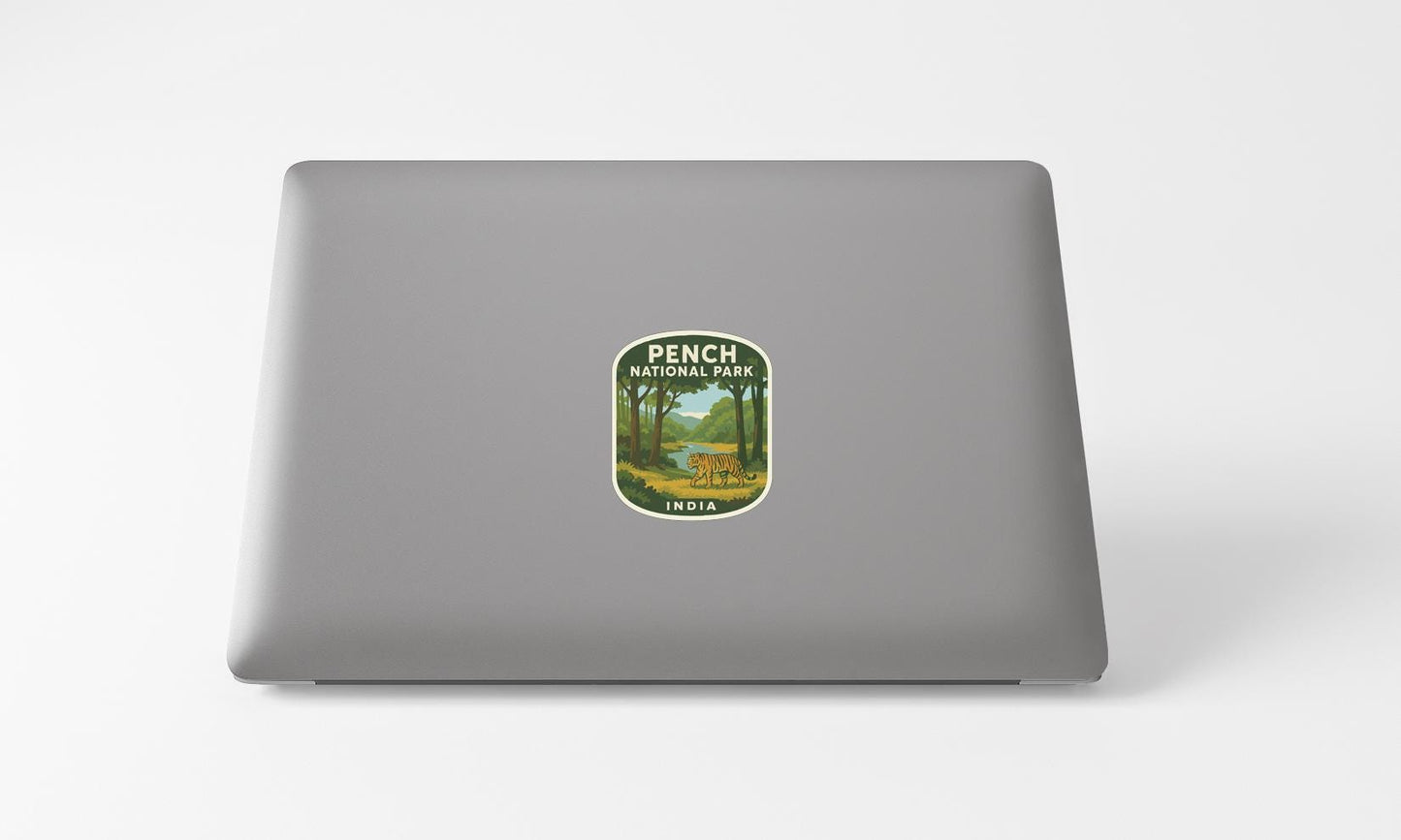 A sticker on the back of a laptop, depicting a scenic landscape with trees and a body of water.